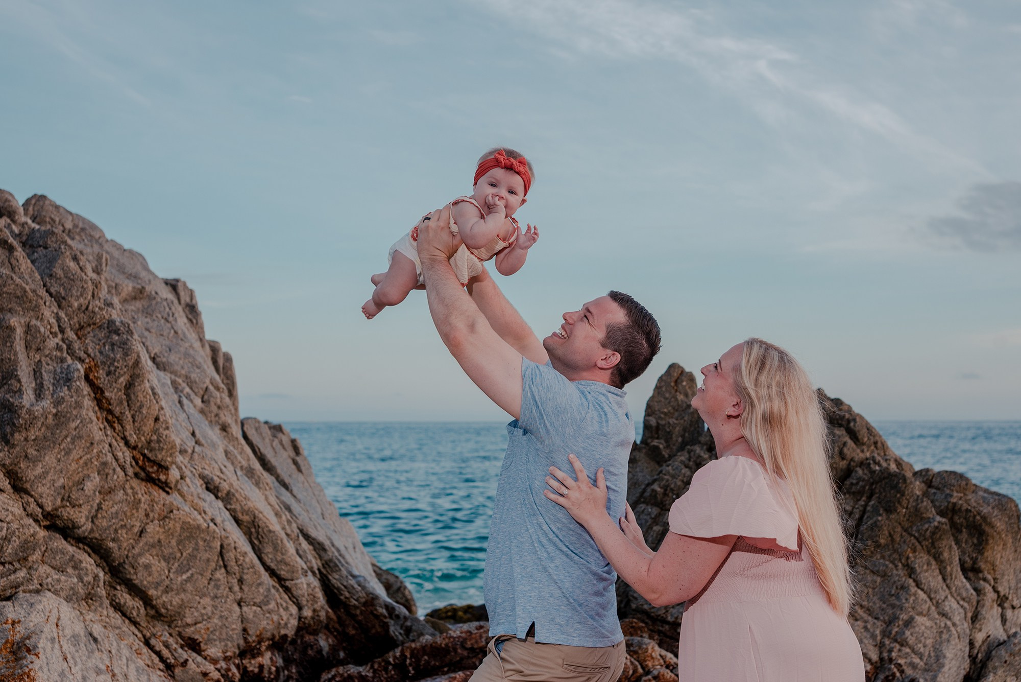 Family with young baby exploring the rock formations at Playa Monumentos Cabo San Lucas during vacation photography session