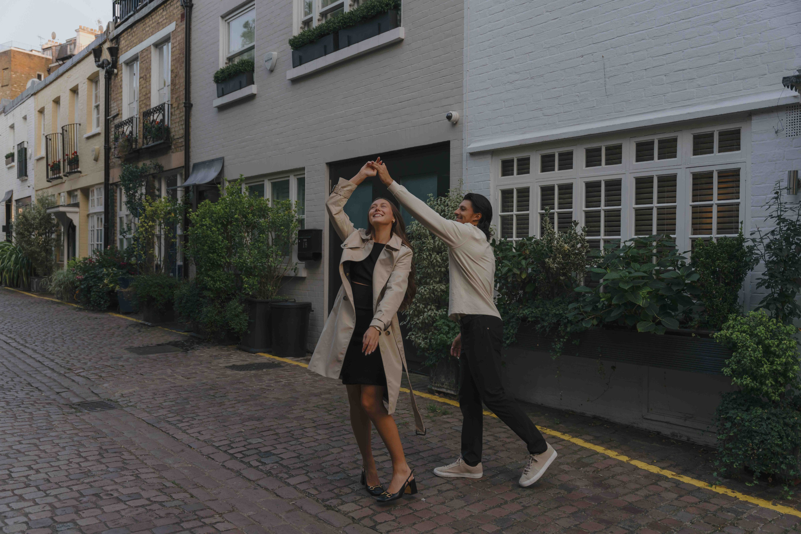 Couple laughing and moving together London engagement shoot candid moment