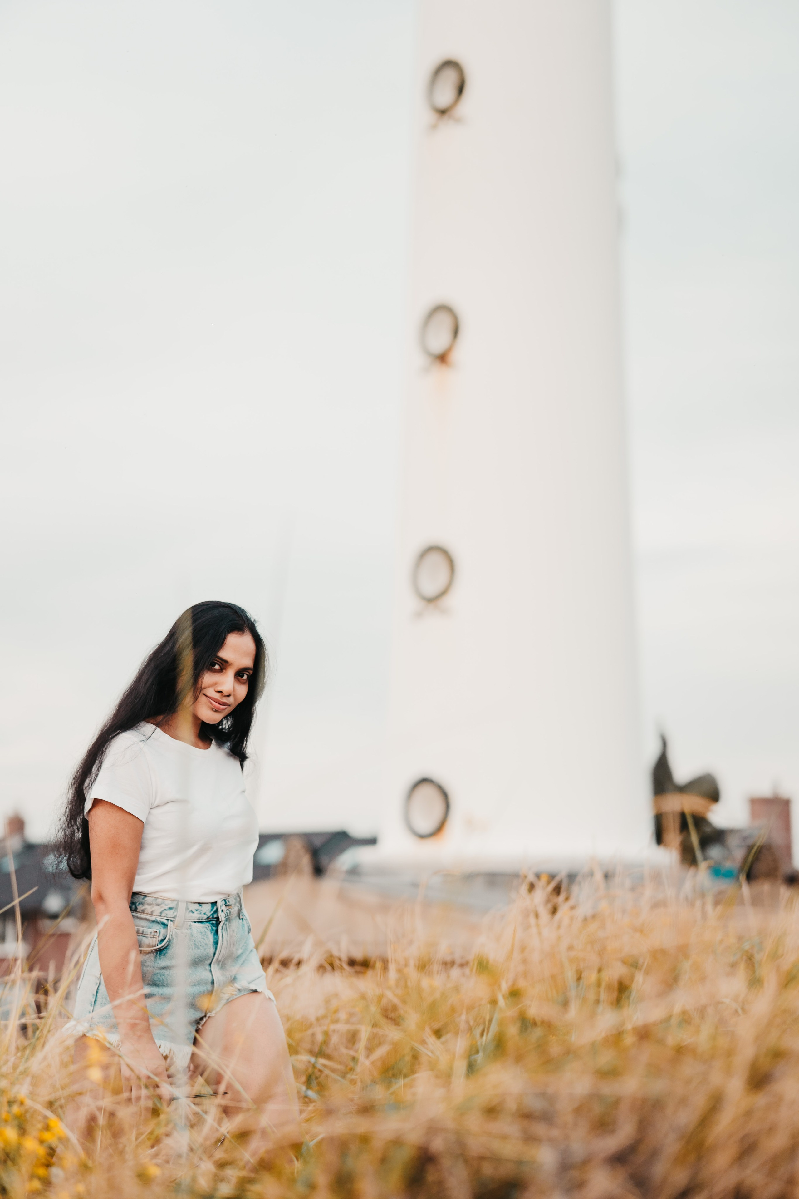 Woman standing in front of a lighthouse in the Netherlands