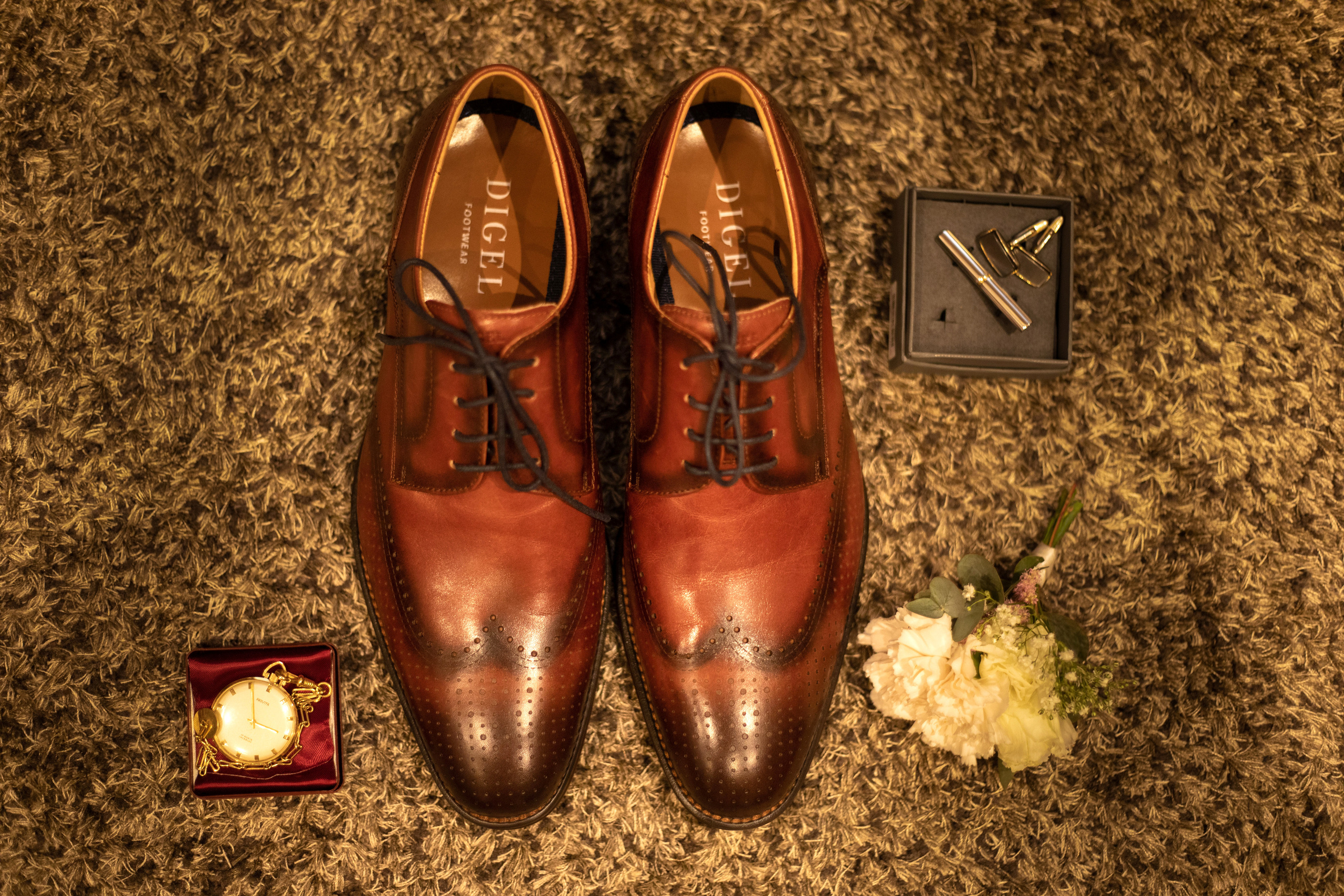 Das Shooting im Hotelzimmer des Bräutigams. Seine Schuhe, Ansteckblume und Anstecken schön ausgebreitet auf dem Boden. Alla hat ein Foto gerade gemacht