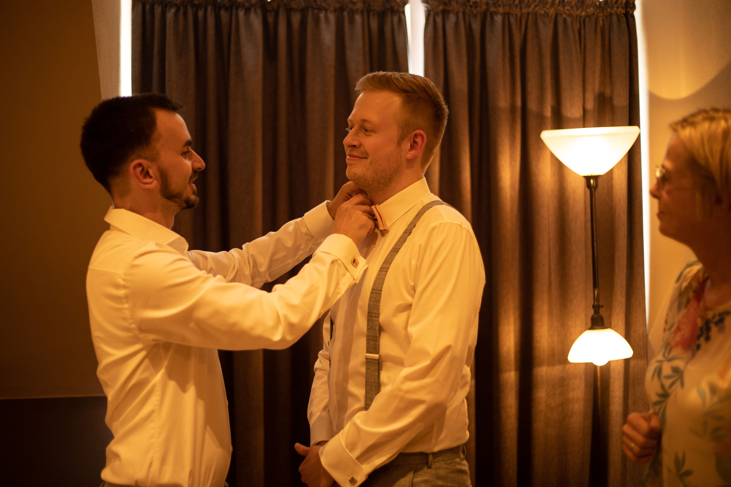 Der Trauzeuge hilft dem Bräutigam beim anziehen