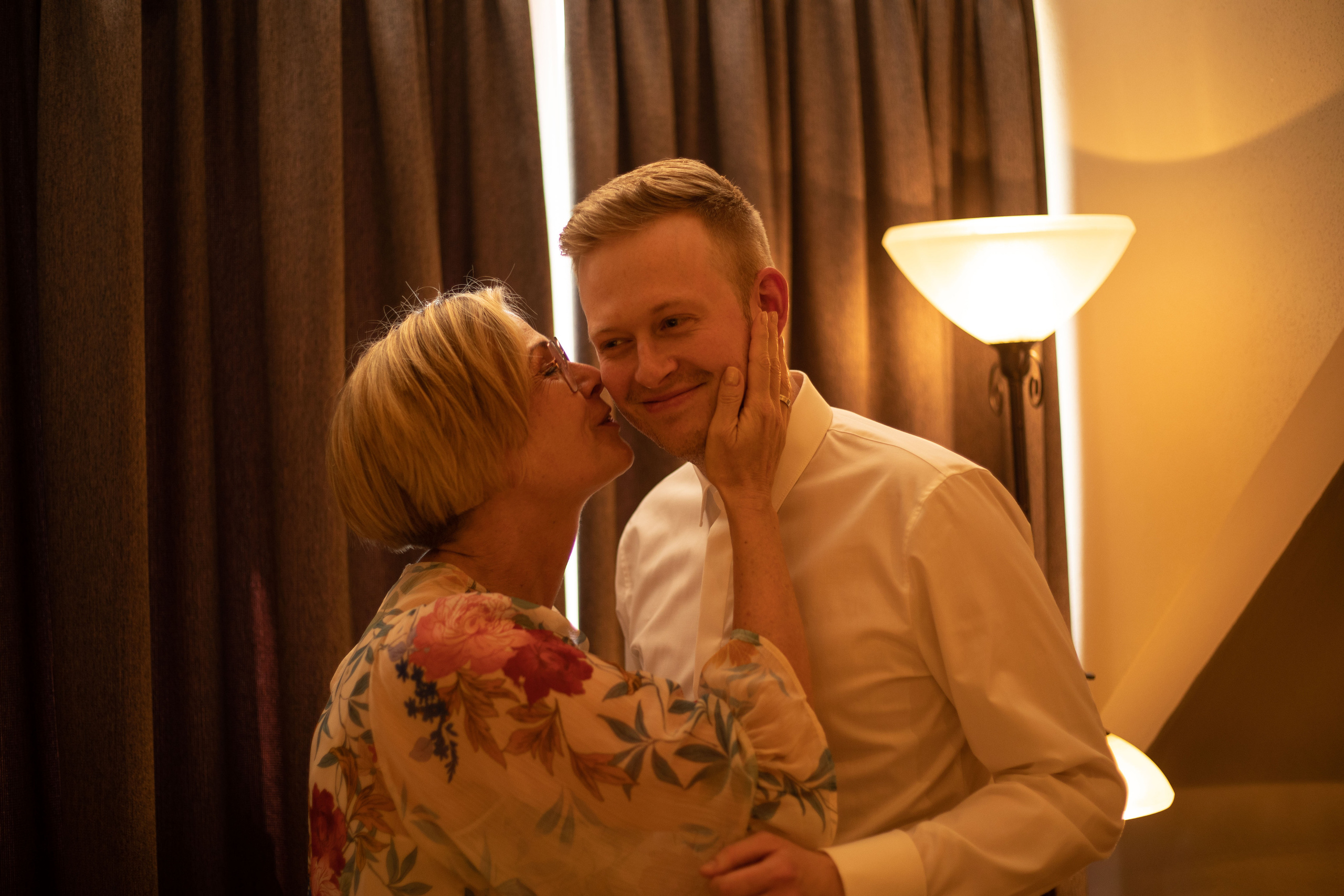 Die Mutter von dem Bräutigam gibt im Kuss an der Wange