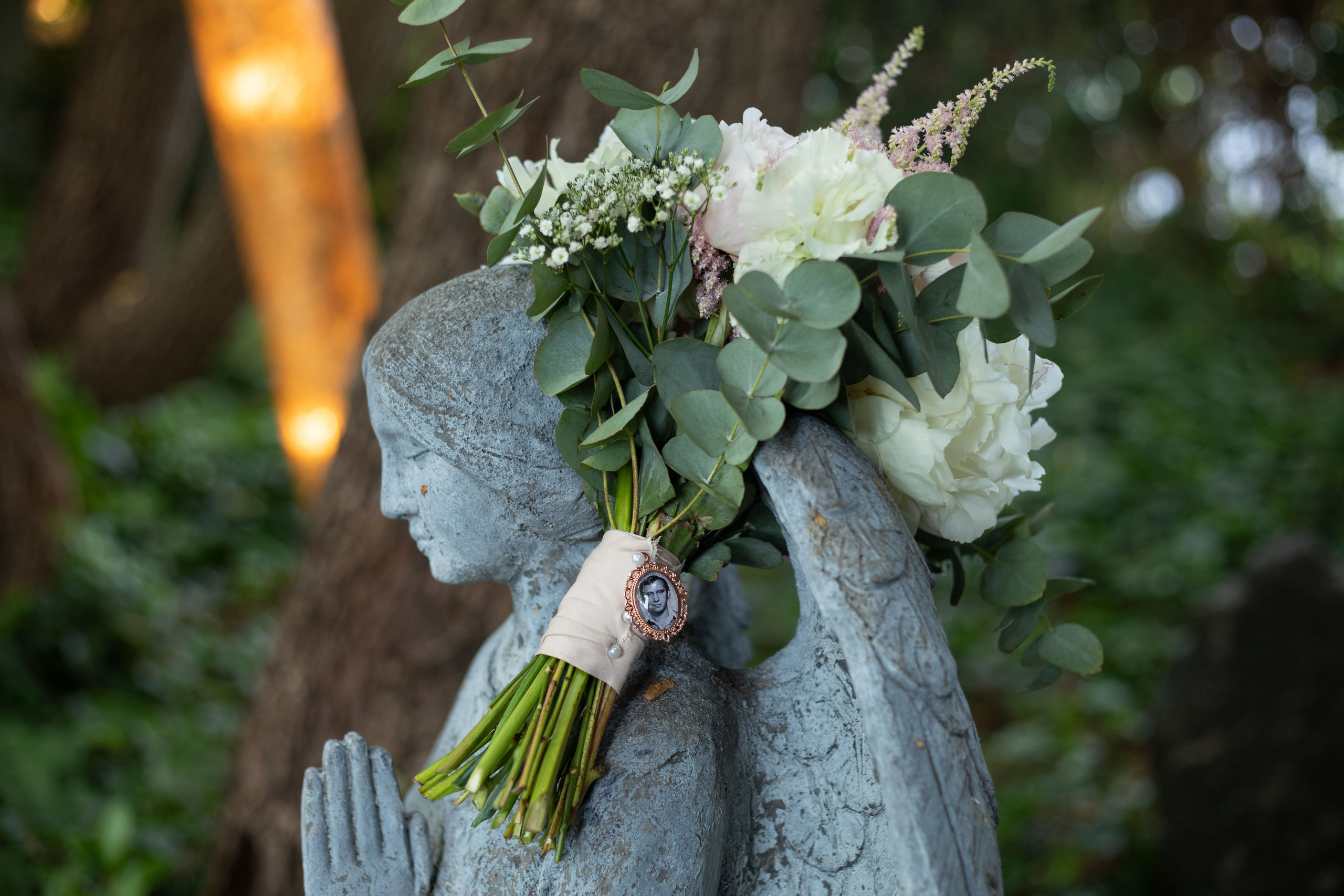 Brautstrauß mit dem Foto von dem verstorbenen Vater in der Blume eingearbeitet, kreatives Bild mit dem Licht