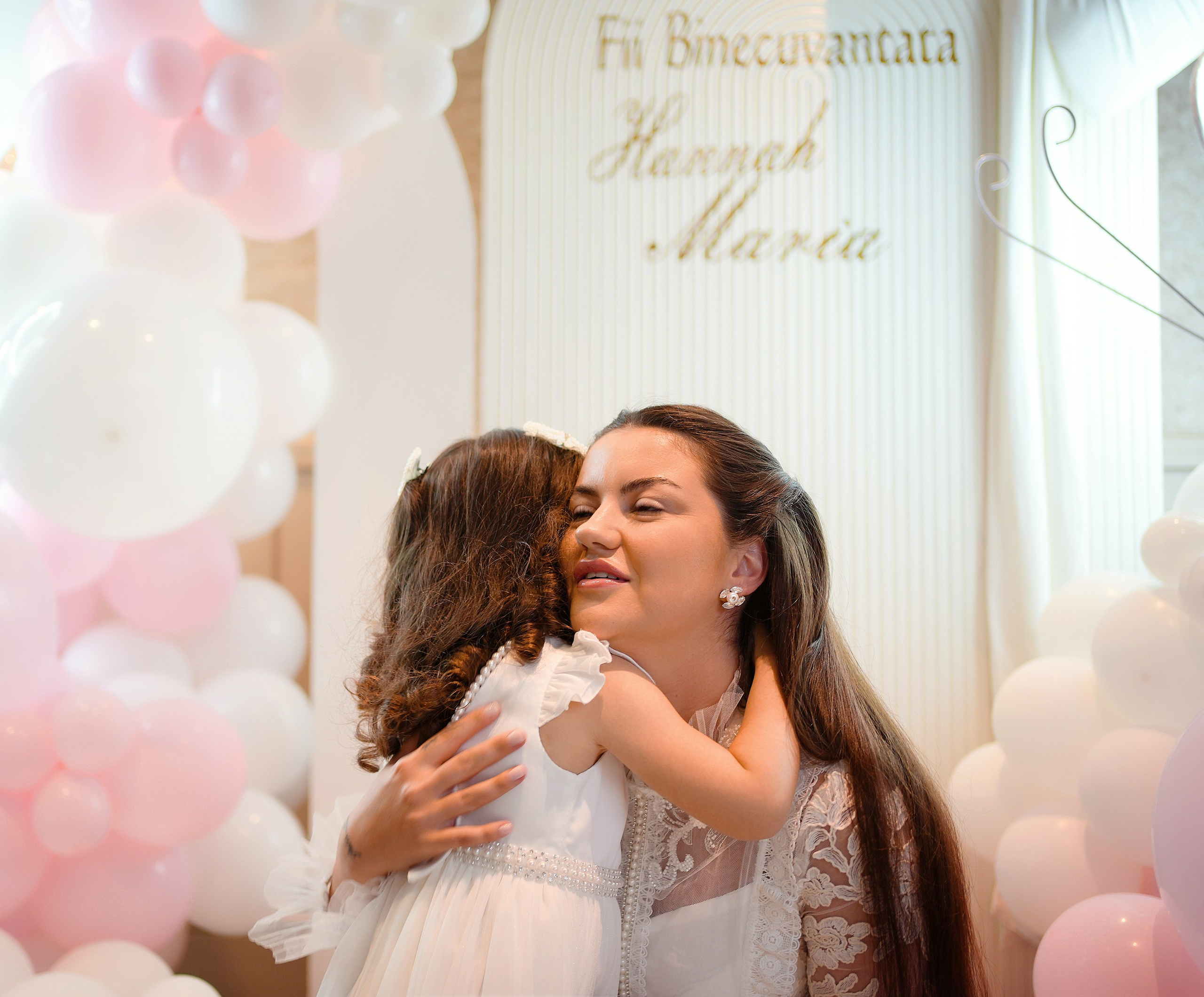 A woman hugging a child at a baptism celebration.
