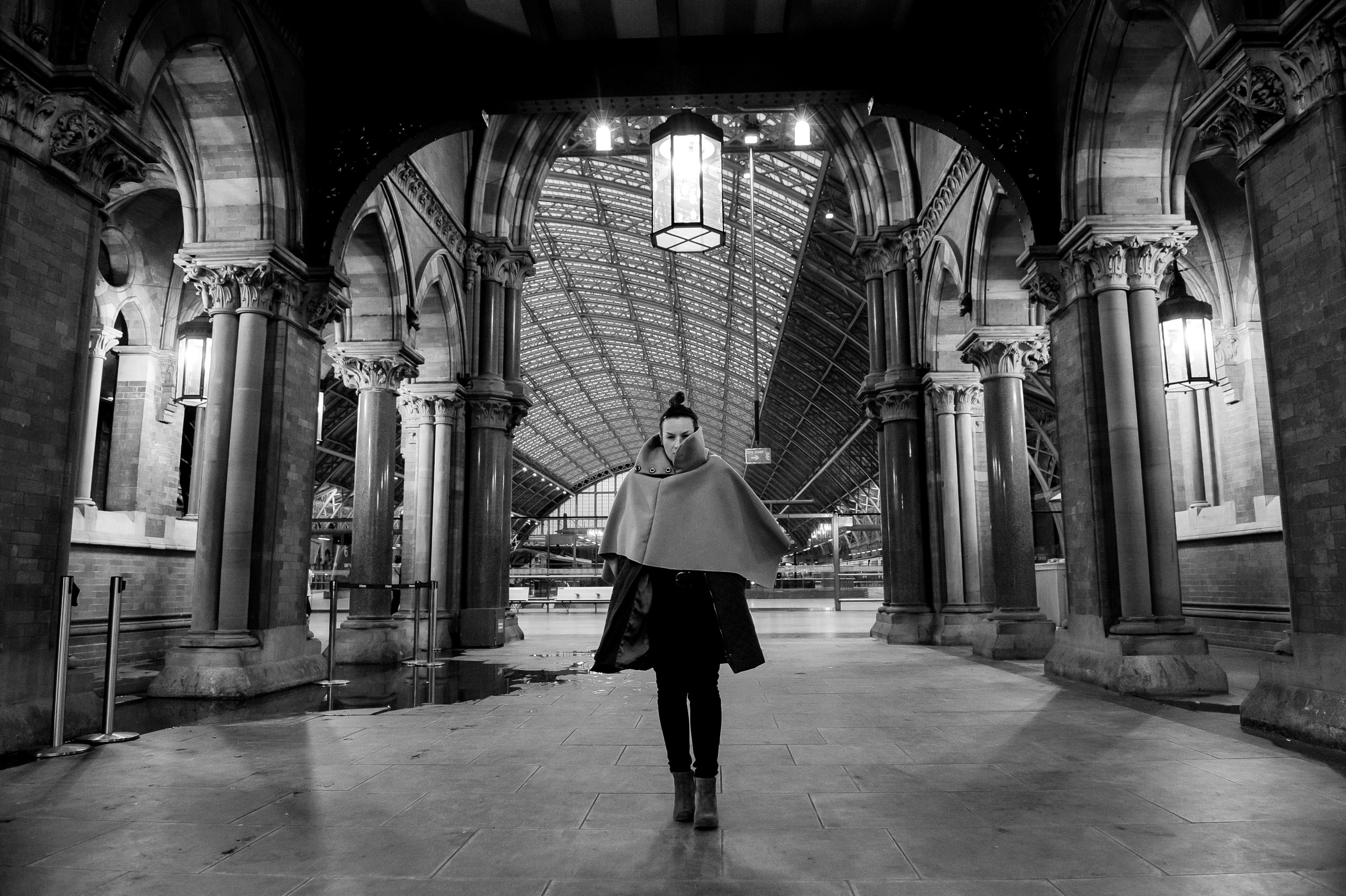 A woman stands under the arch of the Renaissance Hotel in London. Behind her is the Eurostar terminal at St. Pancras International Station.