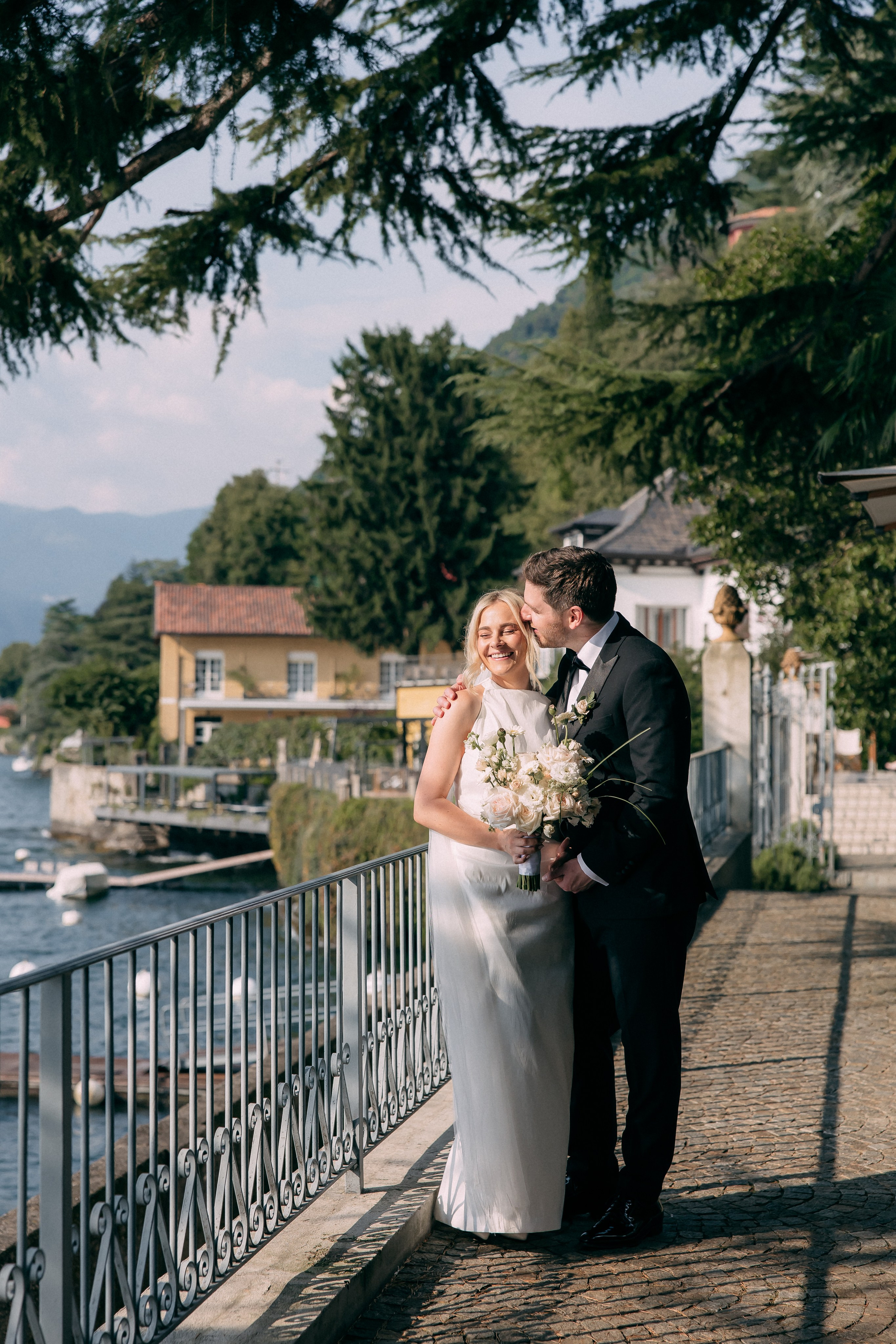 Bride and groom embracing by the lake at Villa Lario, Italy
