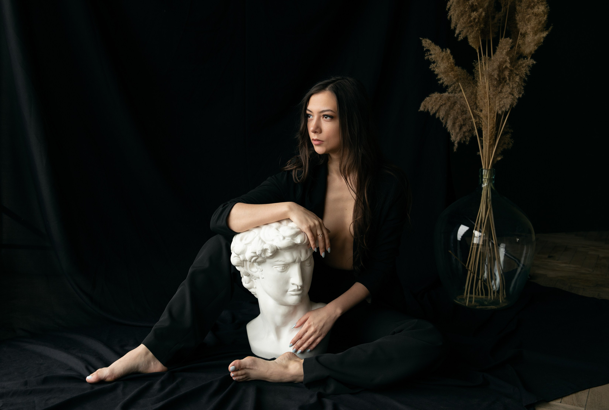  Frau im schwarzen Anzug mit David-Büste posierend