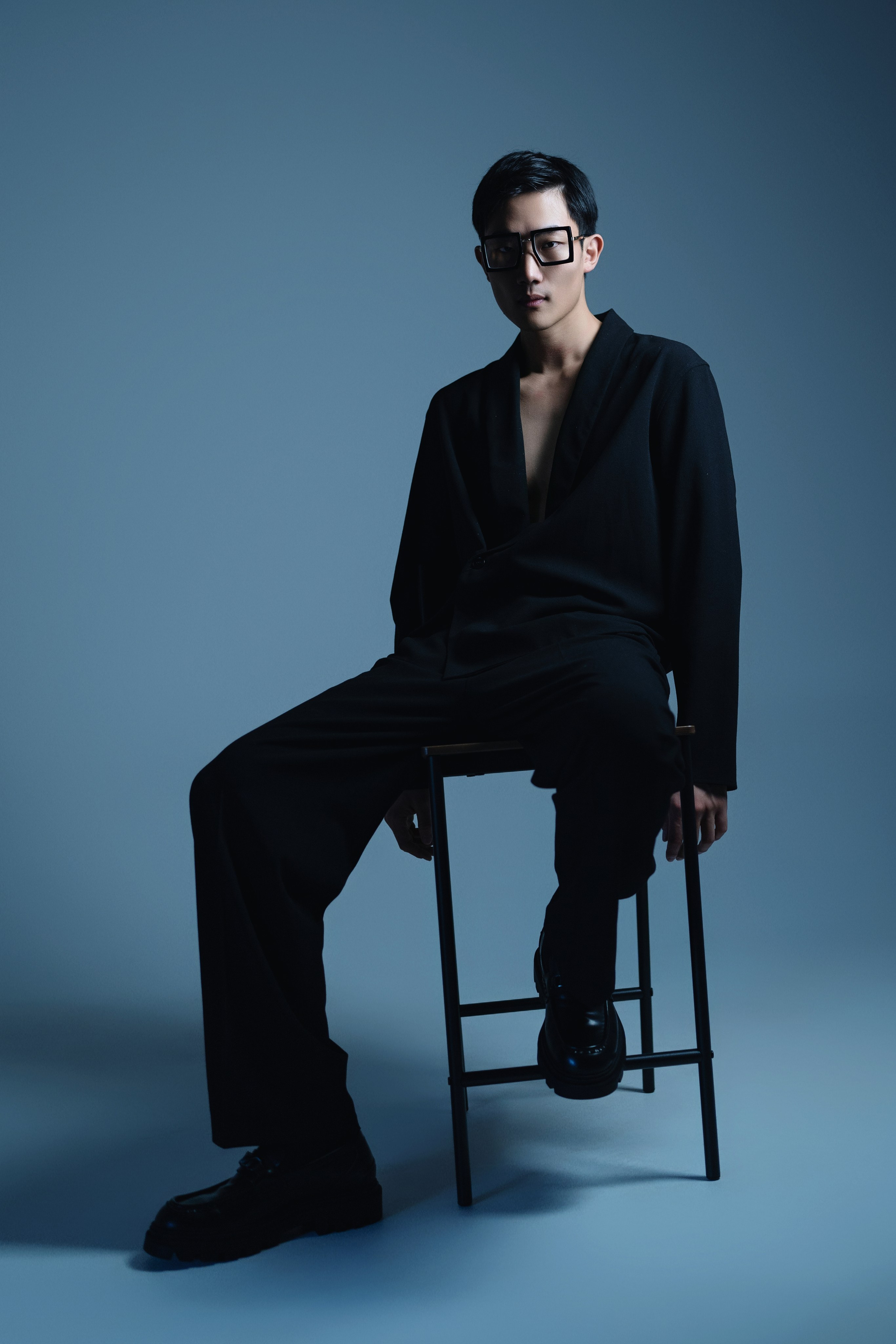 London Fashion Photography with Cinematic Lighting – A model styled in black, posed against a contrasting background, lit by cinematic, high-contrast lighting for a fashion-forward look