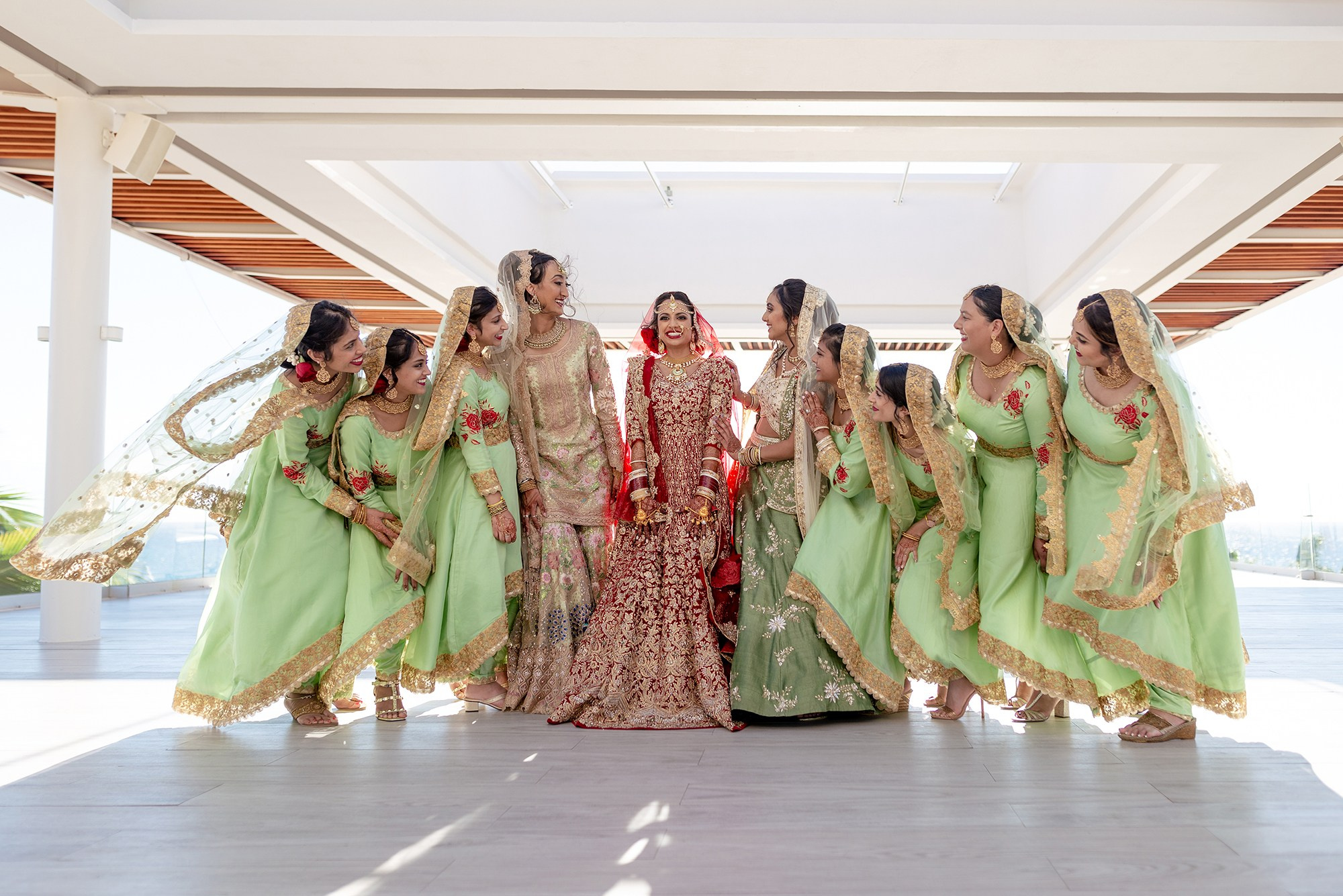 Indian bride with bridesmaids wearing traditional outfits during Baraat ceremony in Los Cabos destination wedding