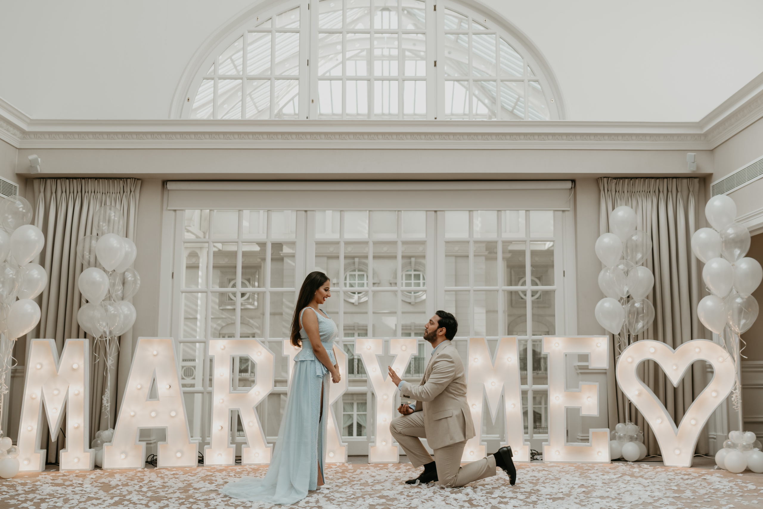 young man standing on one knee with the ring and making proposal to young women 