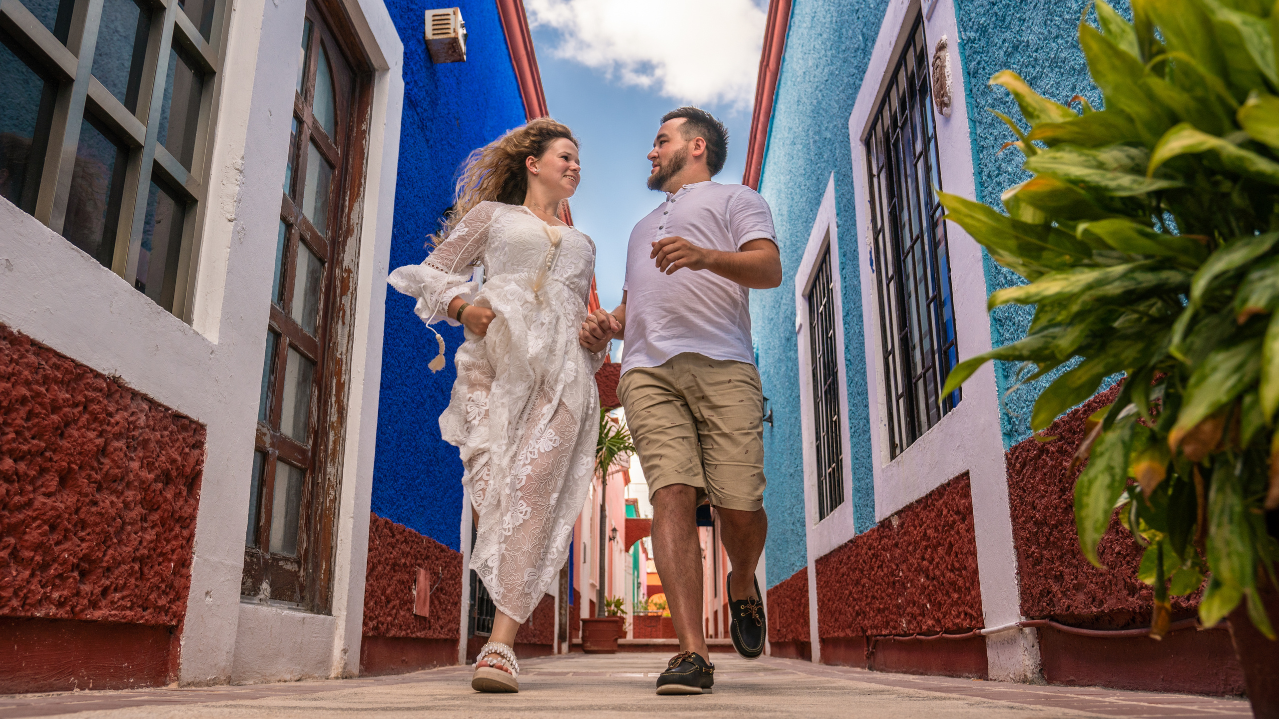 Carefree and joyful moment between two lovers surrounded by Mexican charm and tropical architecture in Cancún.