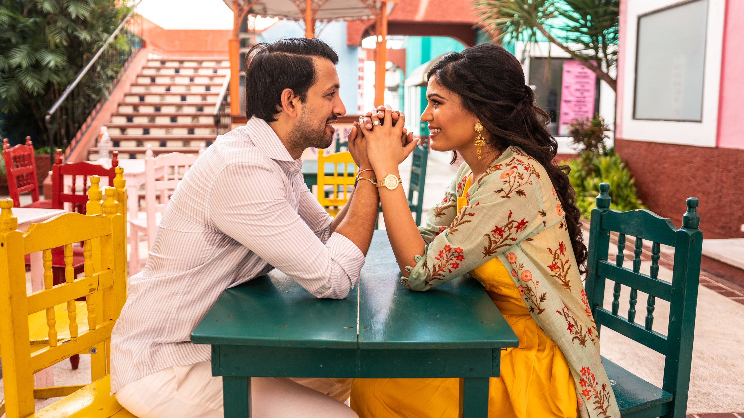 Artistic photo of a couple sitting on tiled Mexican stairs in Cancún, highlighting their chemistry and cultural surroundings