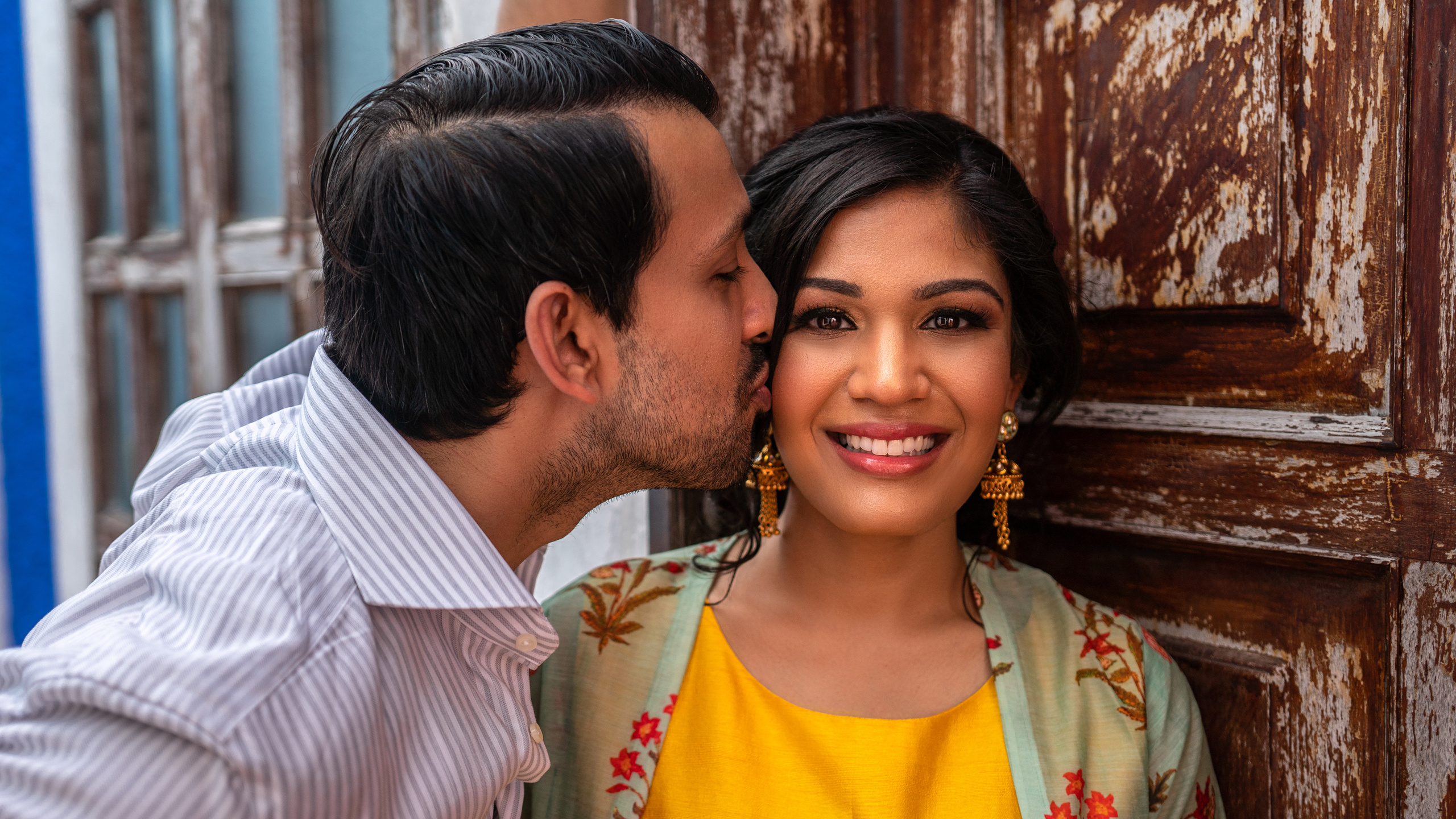 Happy couple laughing in a boutique-style courtyard in Cancún, surrounded by tropical plants and colonial charm — perfect for vacation memories.