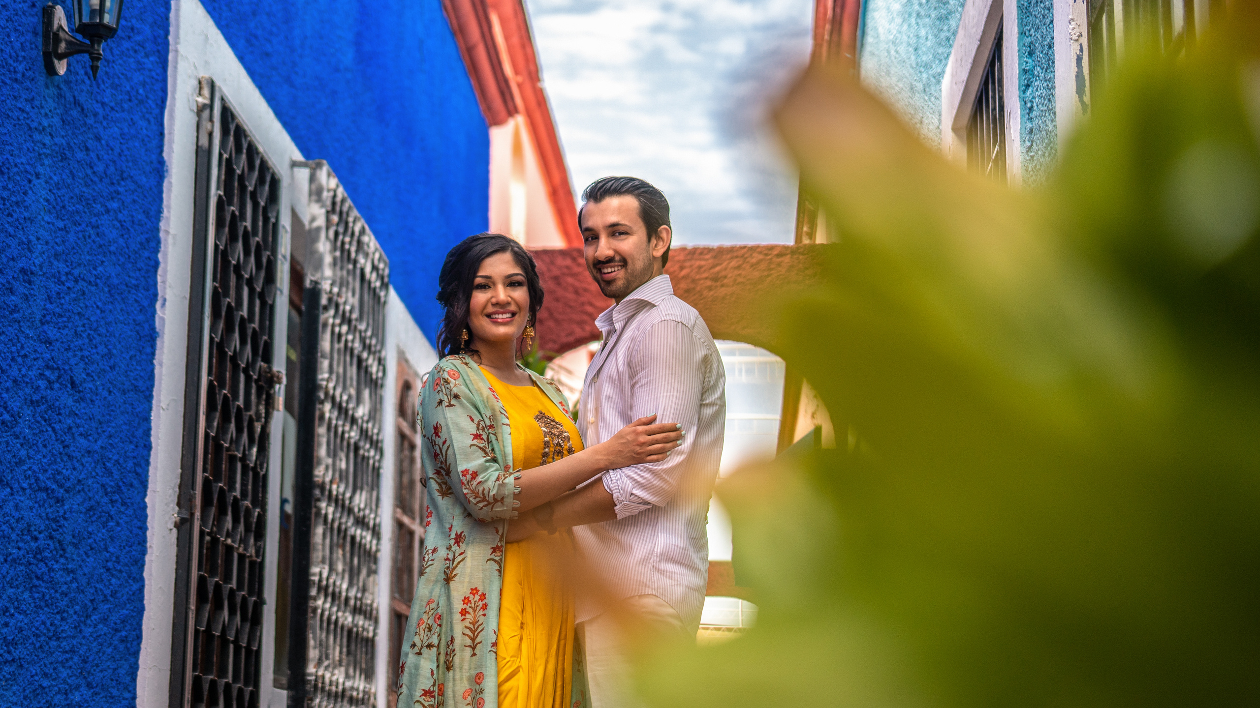 Romantic travel couple session in downtown Cancún with warm tones, floral details, and a Mexican architectural backdrop.