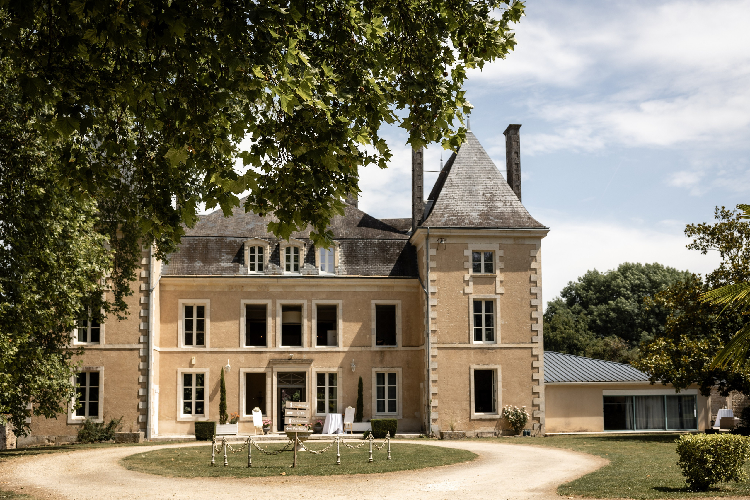 Front façade of Château de la Borderie above the gravel drive on a summer afternoon