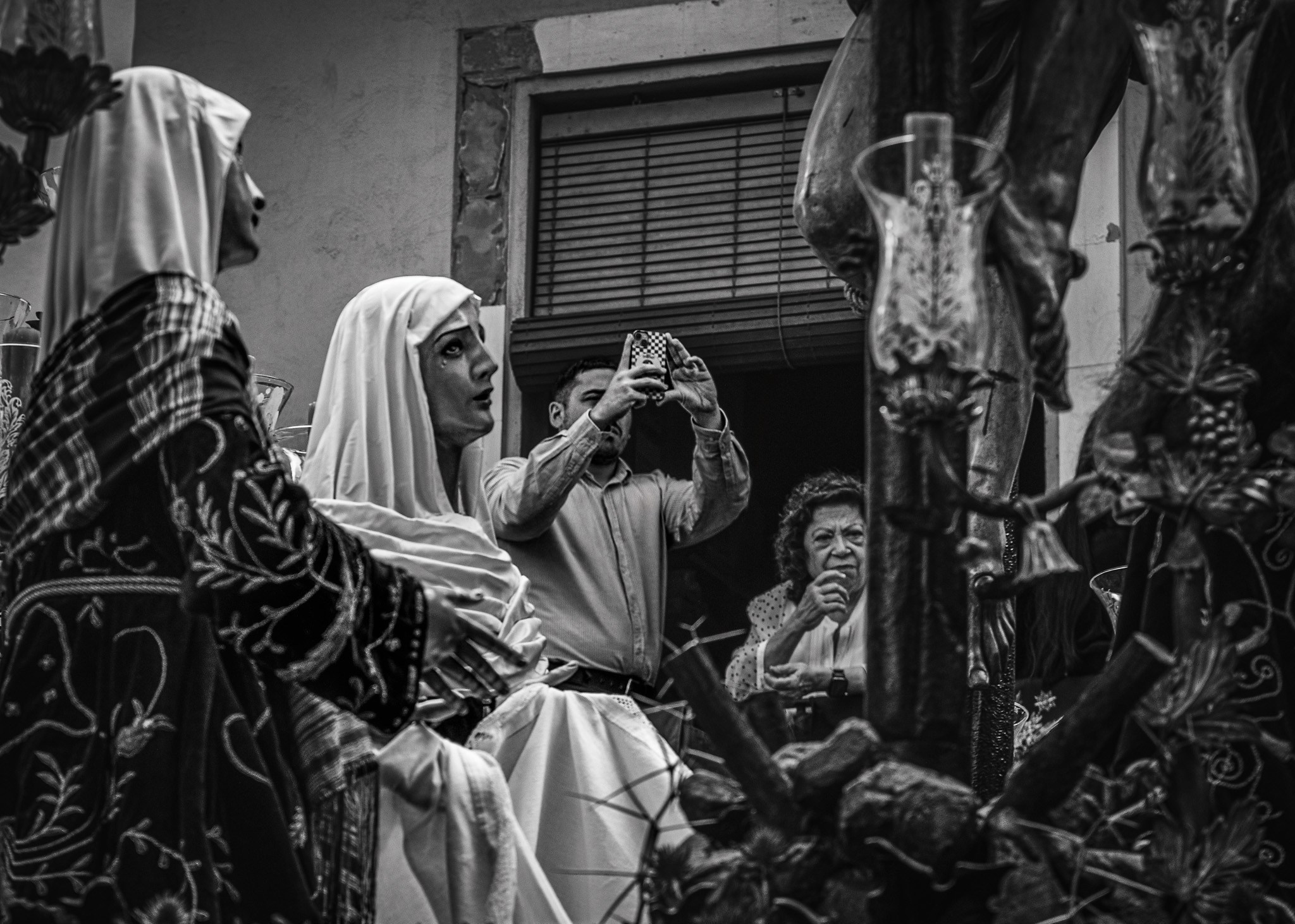 Man photographing religious float during Semana Santa procession in Spain