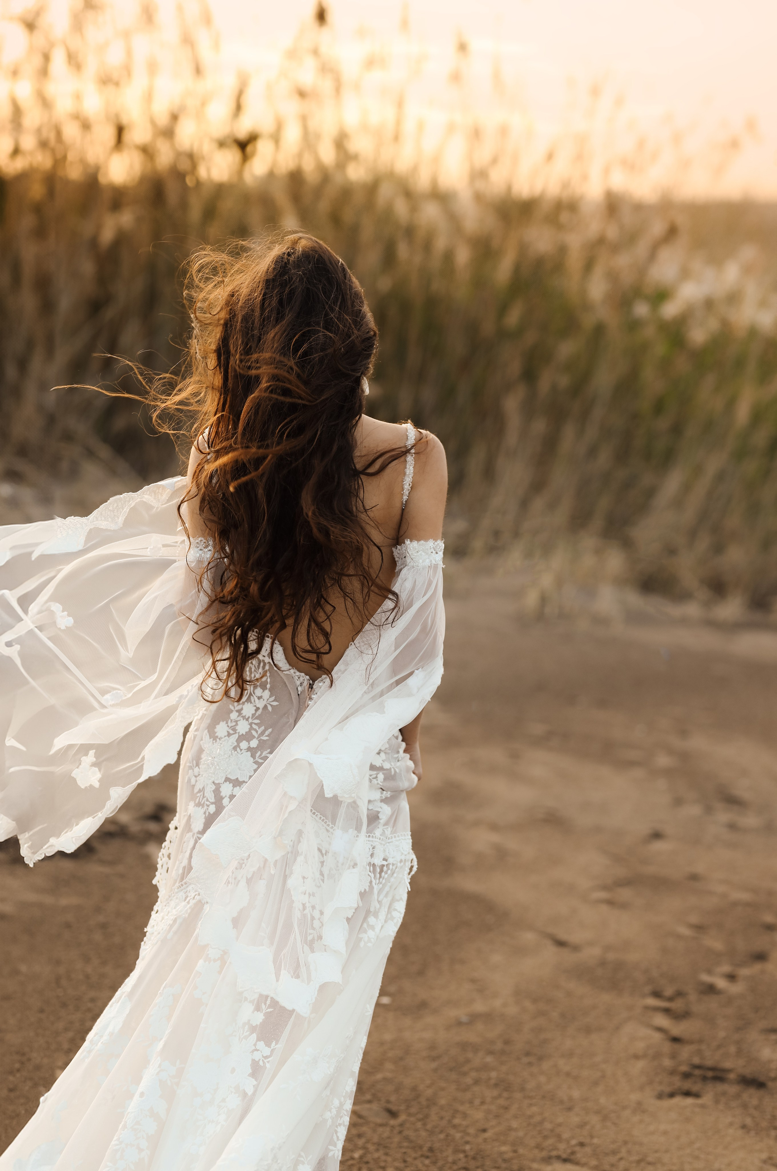 A portrait of girl in a wedding dress on a sunset background in reeds. Rhodes, Greece