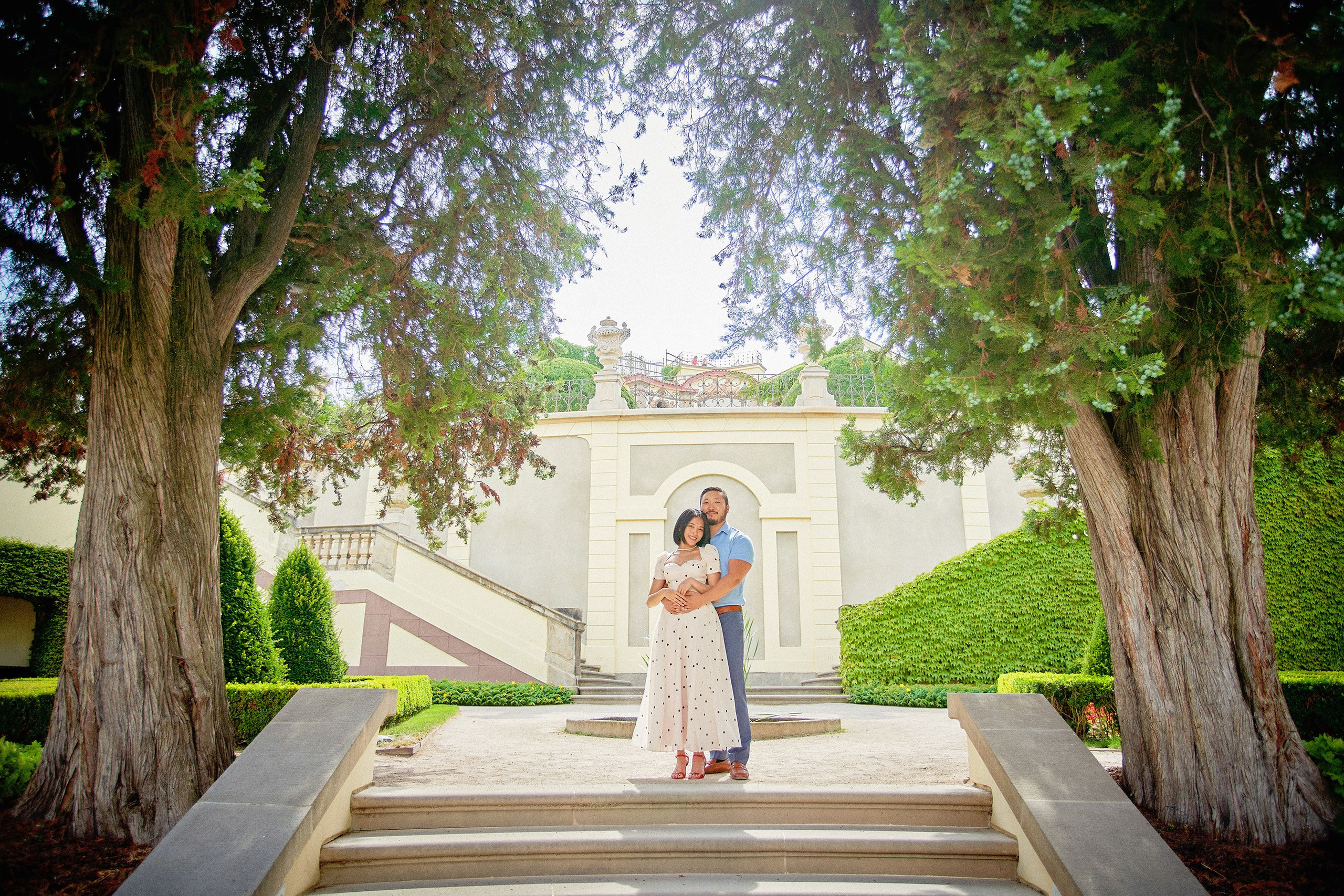 Couple sharing a gentle embrace surrounded by soft natural light in Vrtba Garden, Prague.
