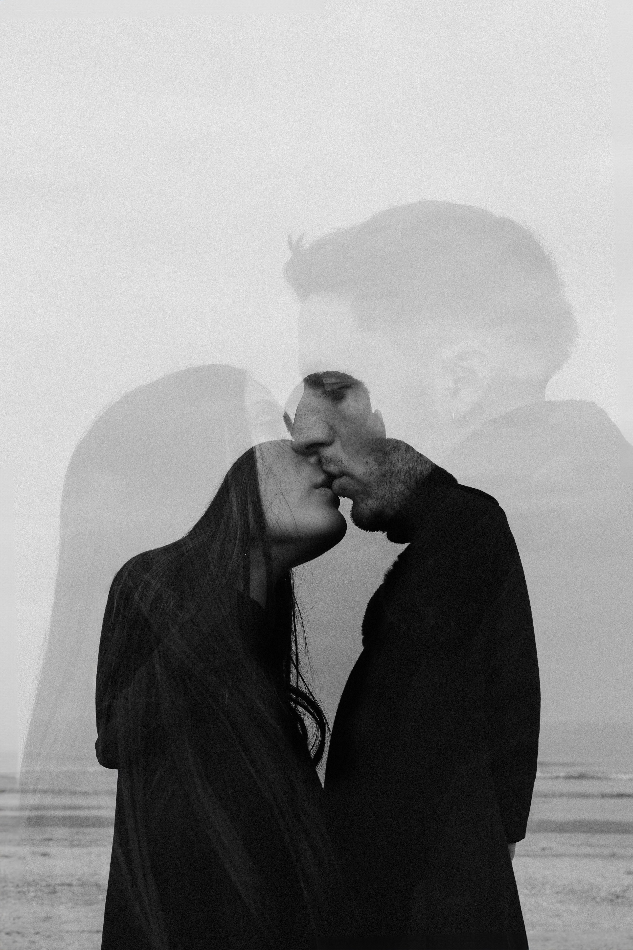 coppia che si bacia con effetto doppia esposizione durante una love story sul mare
