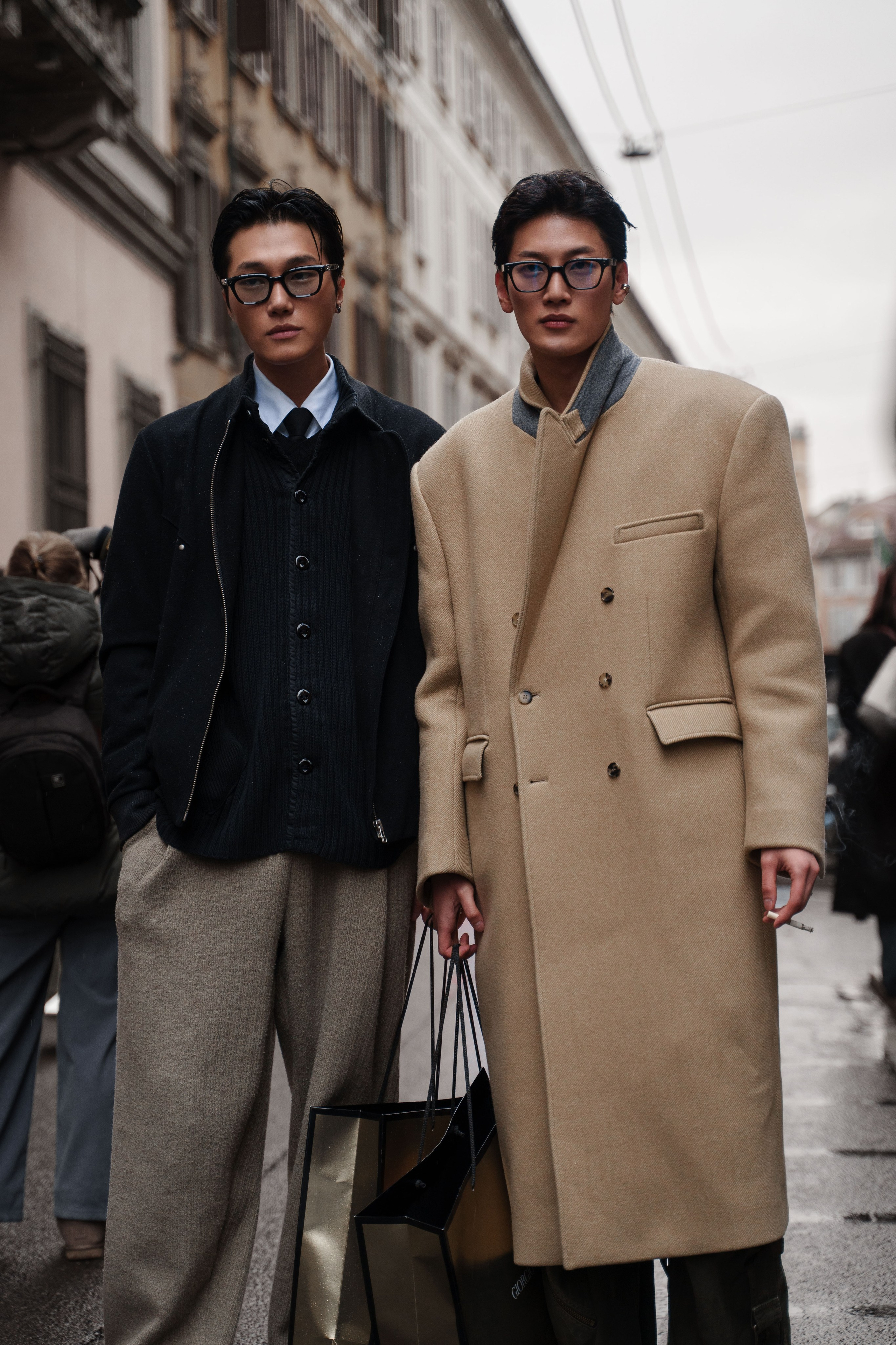 Street fashion photography Milan – two stylish men in classic coats and glasses posing at Milan Fashion Week