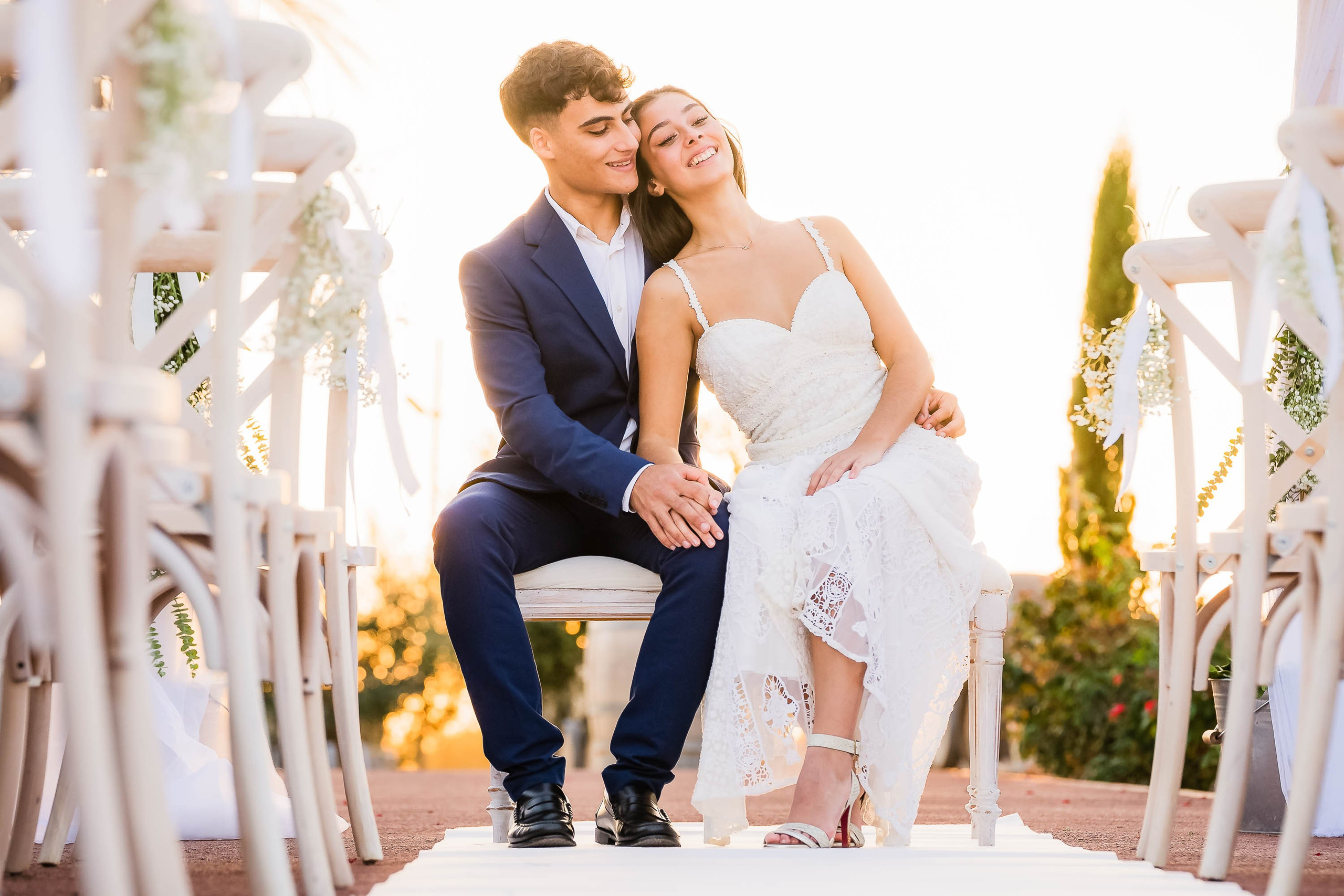 Sunny Mallorca vineyard as a ceremony backdrop, where bride and groom hug each other