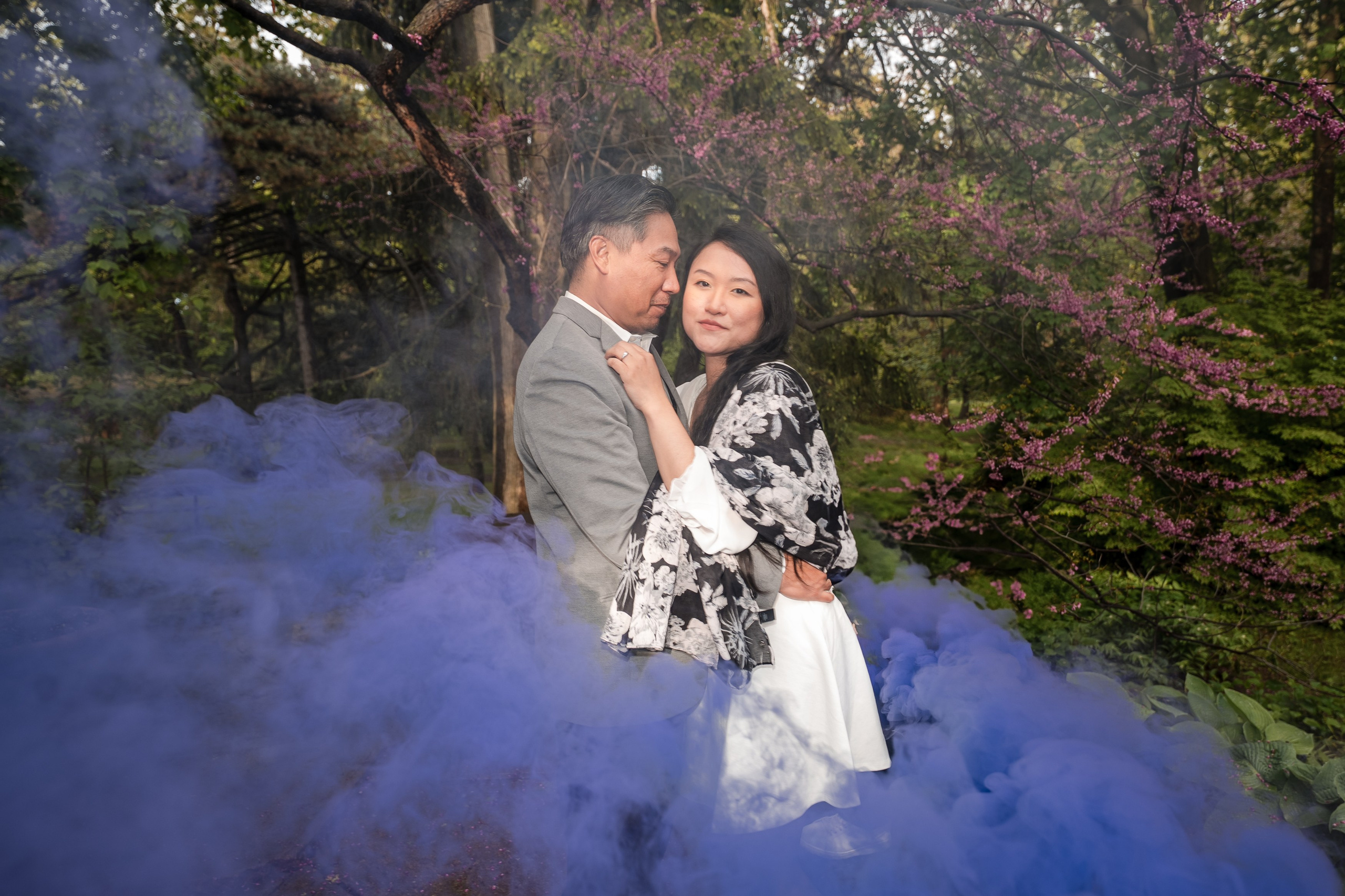 Playful engagement photo in a blooming spring garden, full of laughter and connection