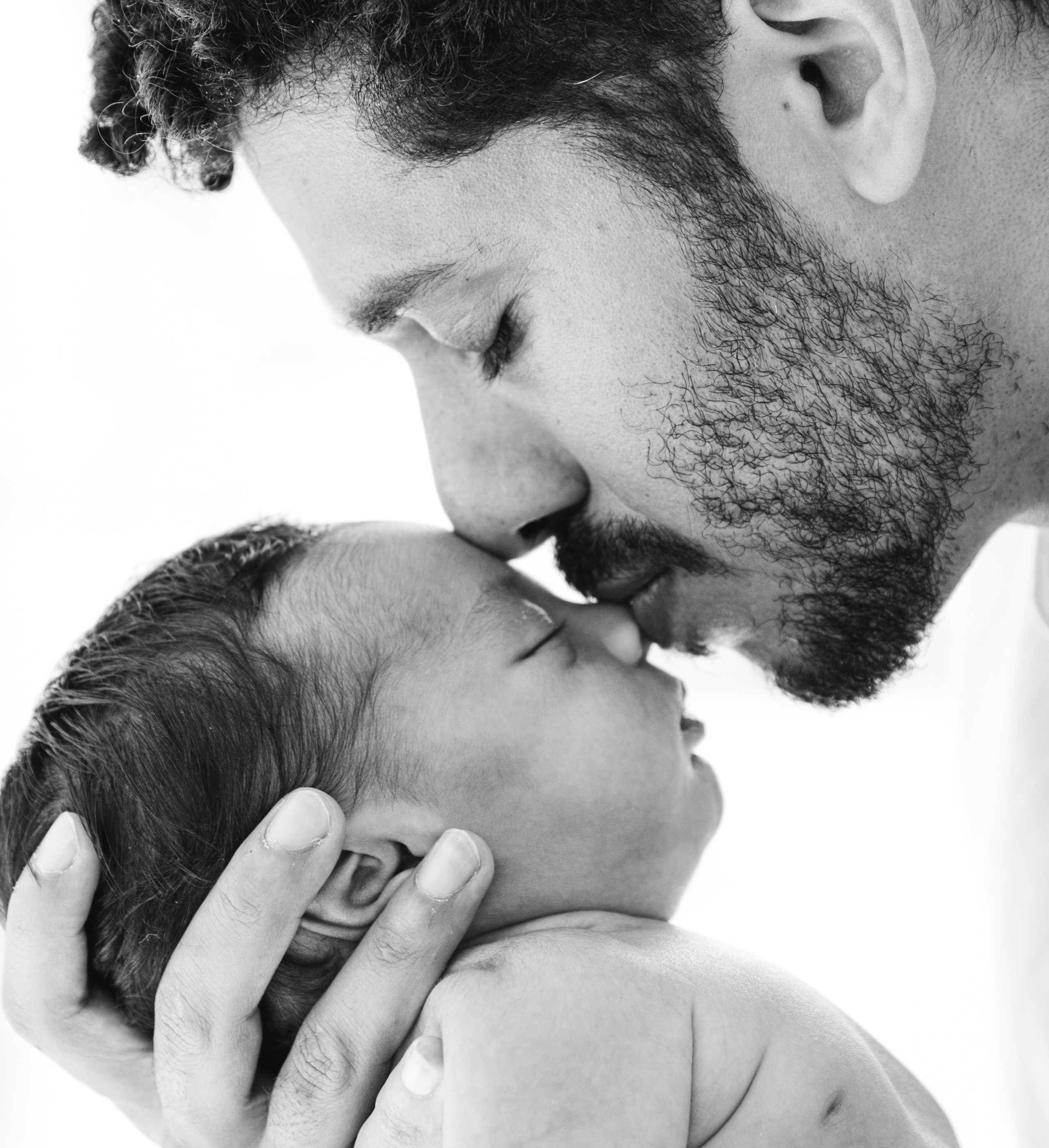 Emotiva foto familiar de recién nacido en Madrid, España — tierno primer plano en blanco y negro de un padre besando suavemente la nariz de su bebé dormido, capturando amor, protección y el vínculo íntimo de la paternidad. Perfecta para quienes buscan sesiones de recién nacido y familia llenas de ternura en Madrid y el centro de España.