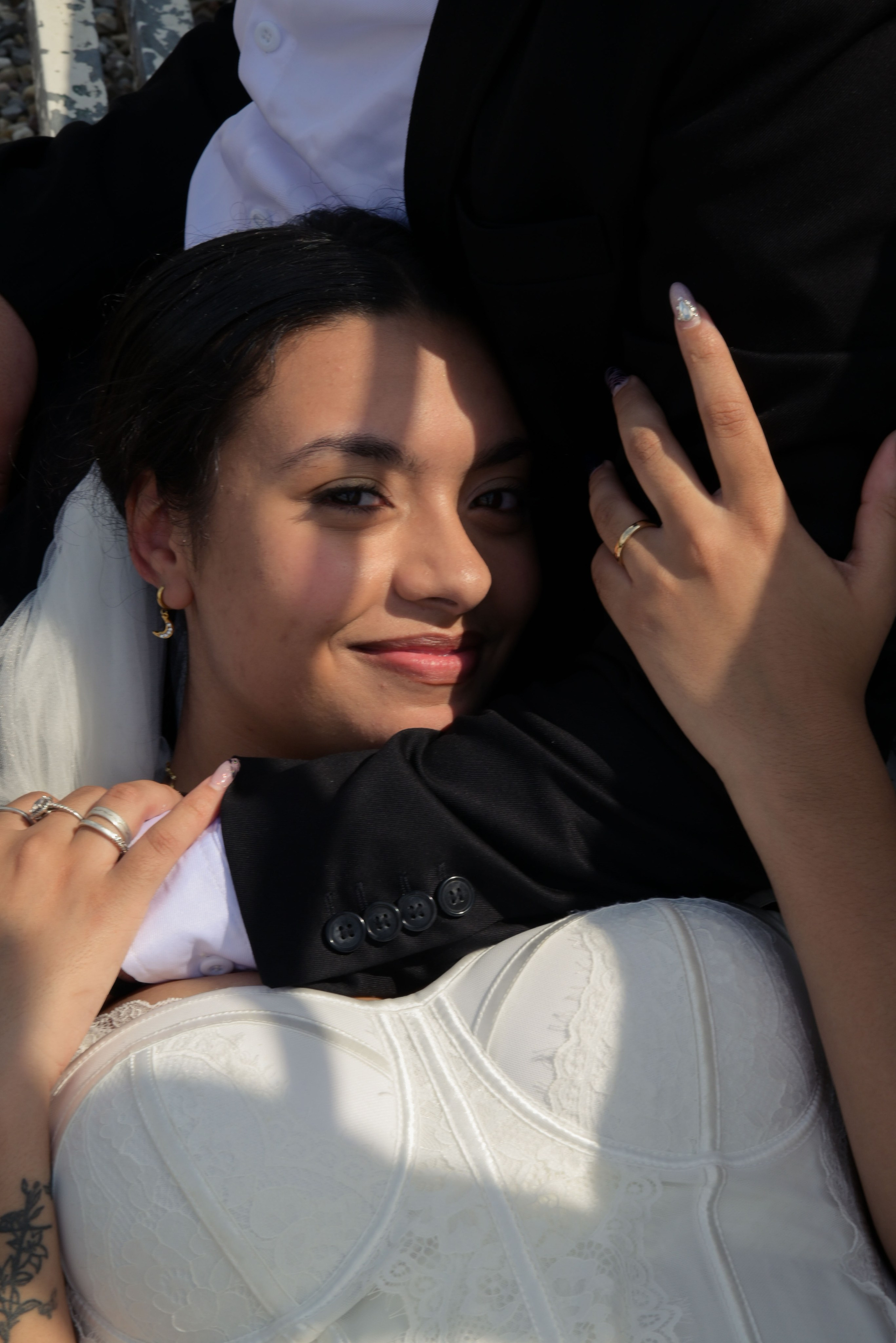 sposa abbraccia lo sposo e sorride e si vede la fede nuziale