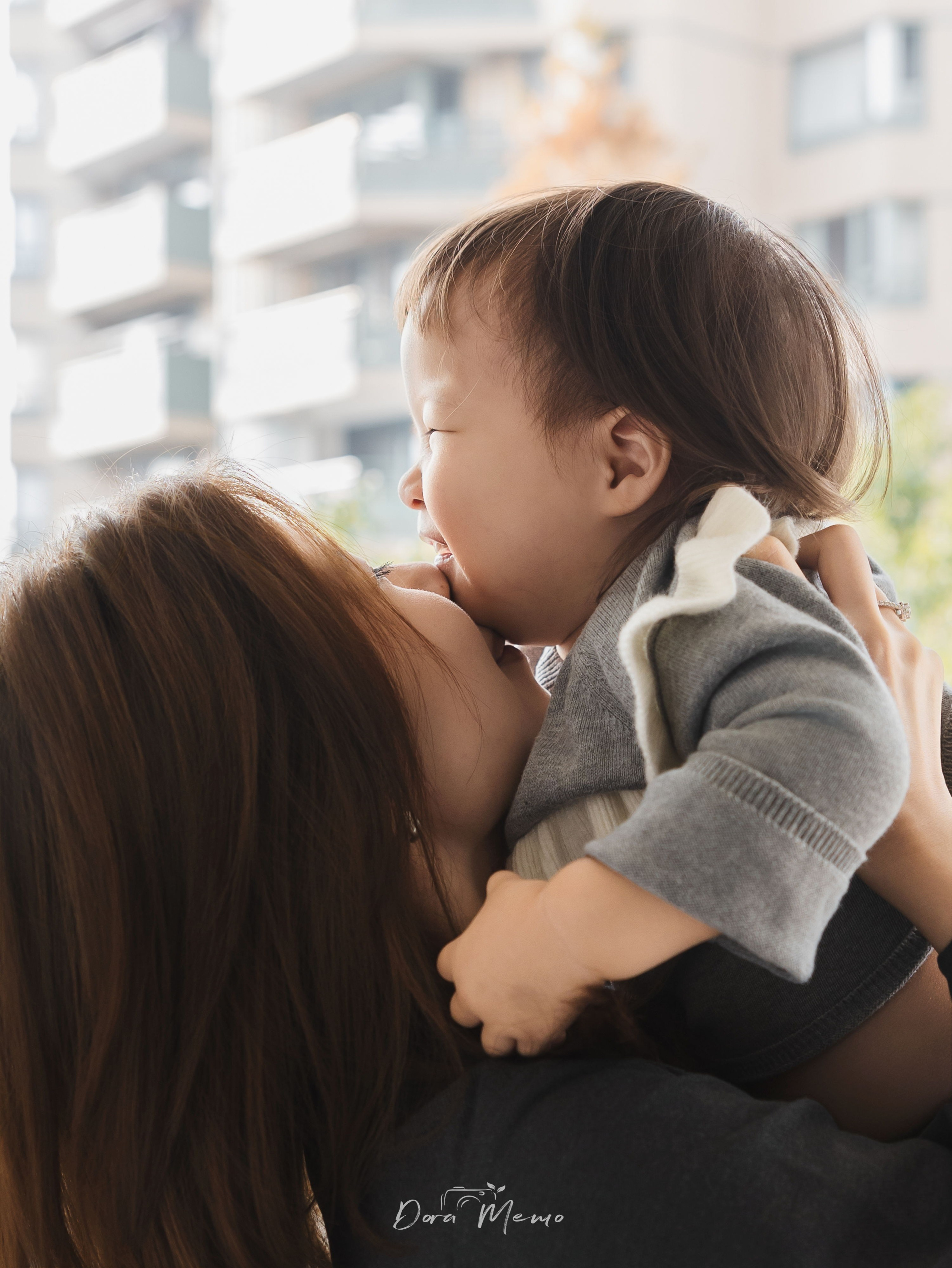 Mother and daughter leaning their foreheads together in a sweet intimate moment, natural family connection documented in Shanghai.
