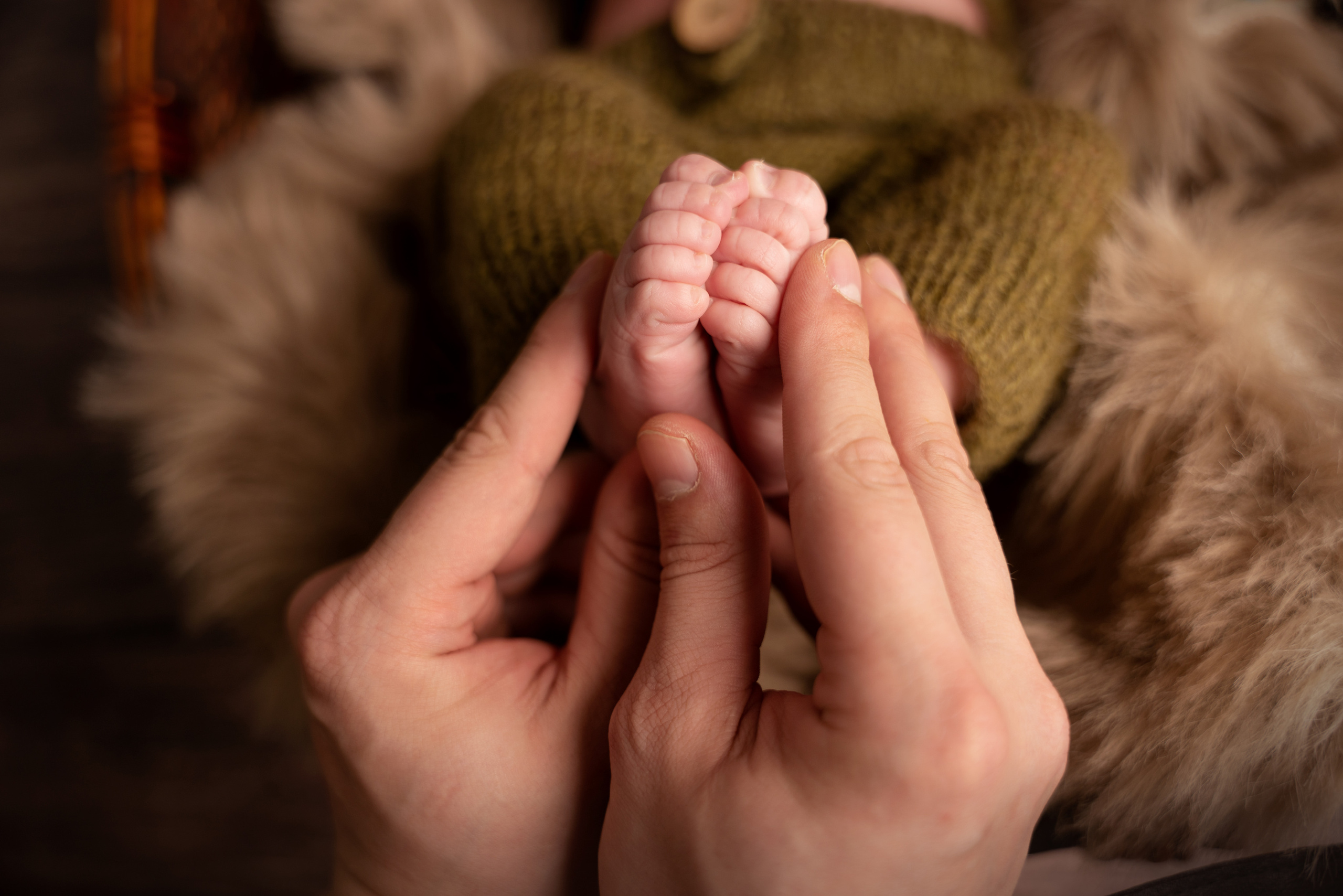 Foto der Füße des Babys in den Händen der Mutter