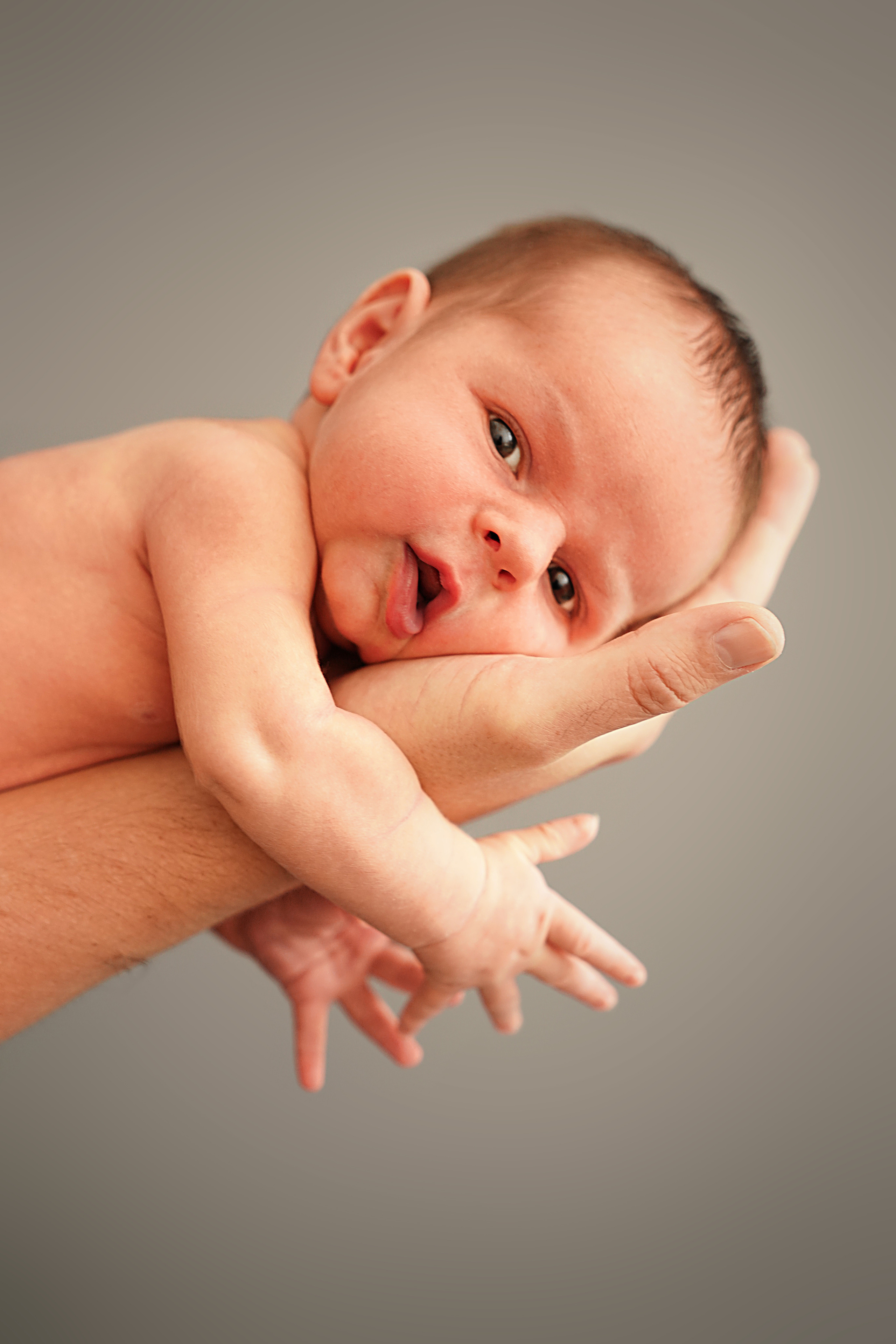 Wange eines neugeborenen Sohnes an Papas Hand