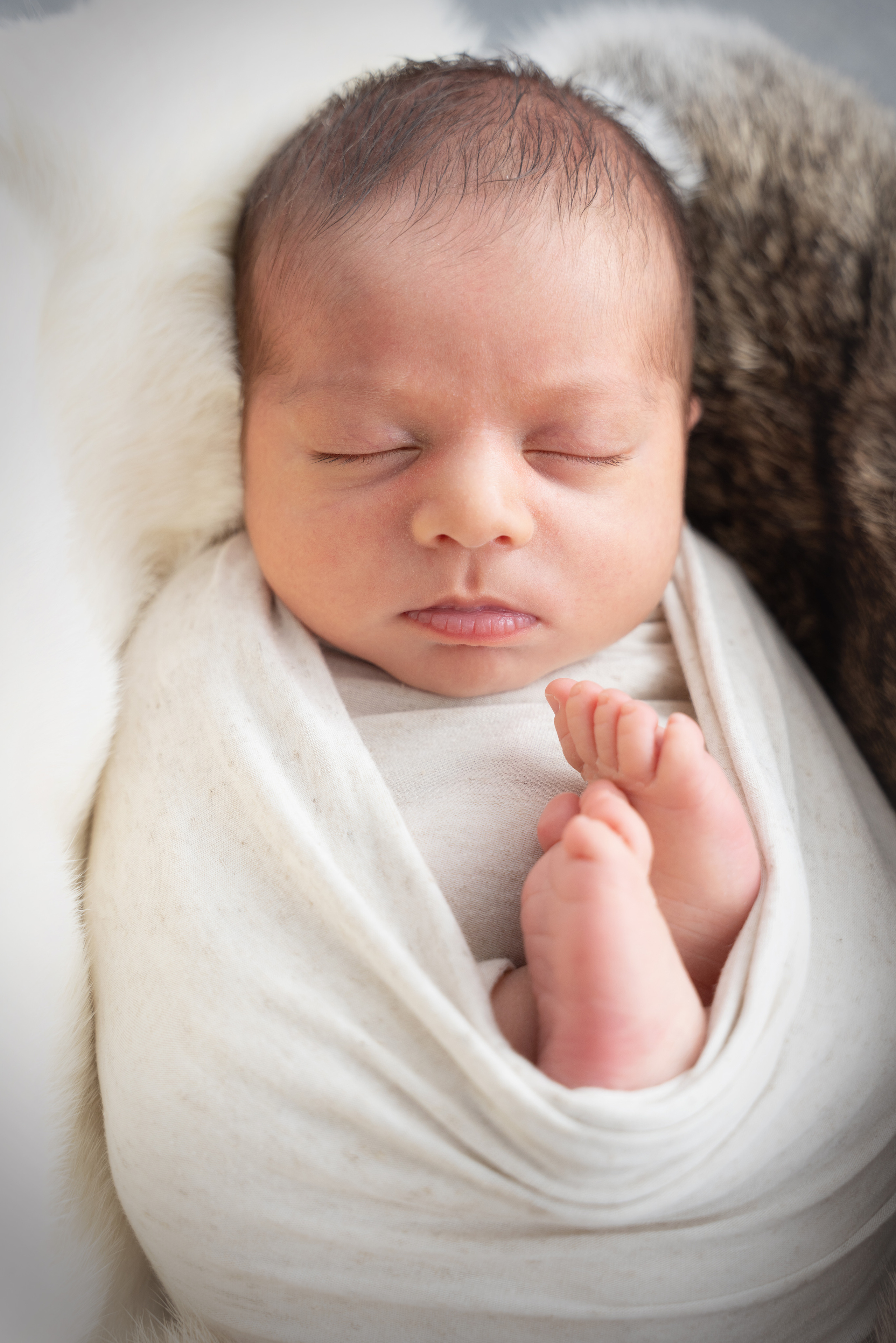 Foto eines Neugeborenen in einem weißen Tuch