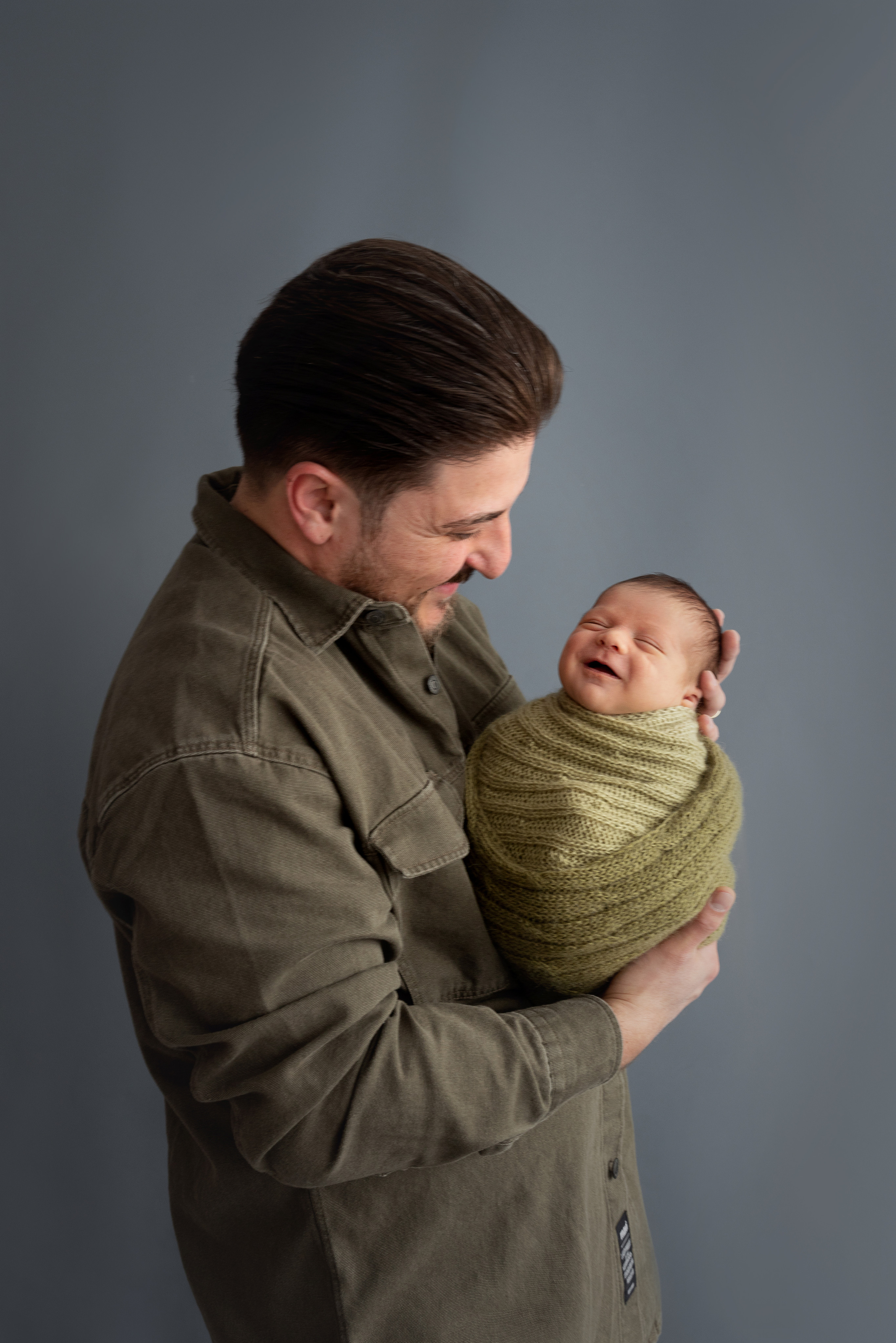 Papa hält sein erstes Kind im Arm, das lacht