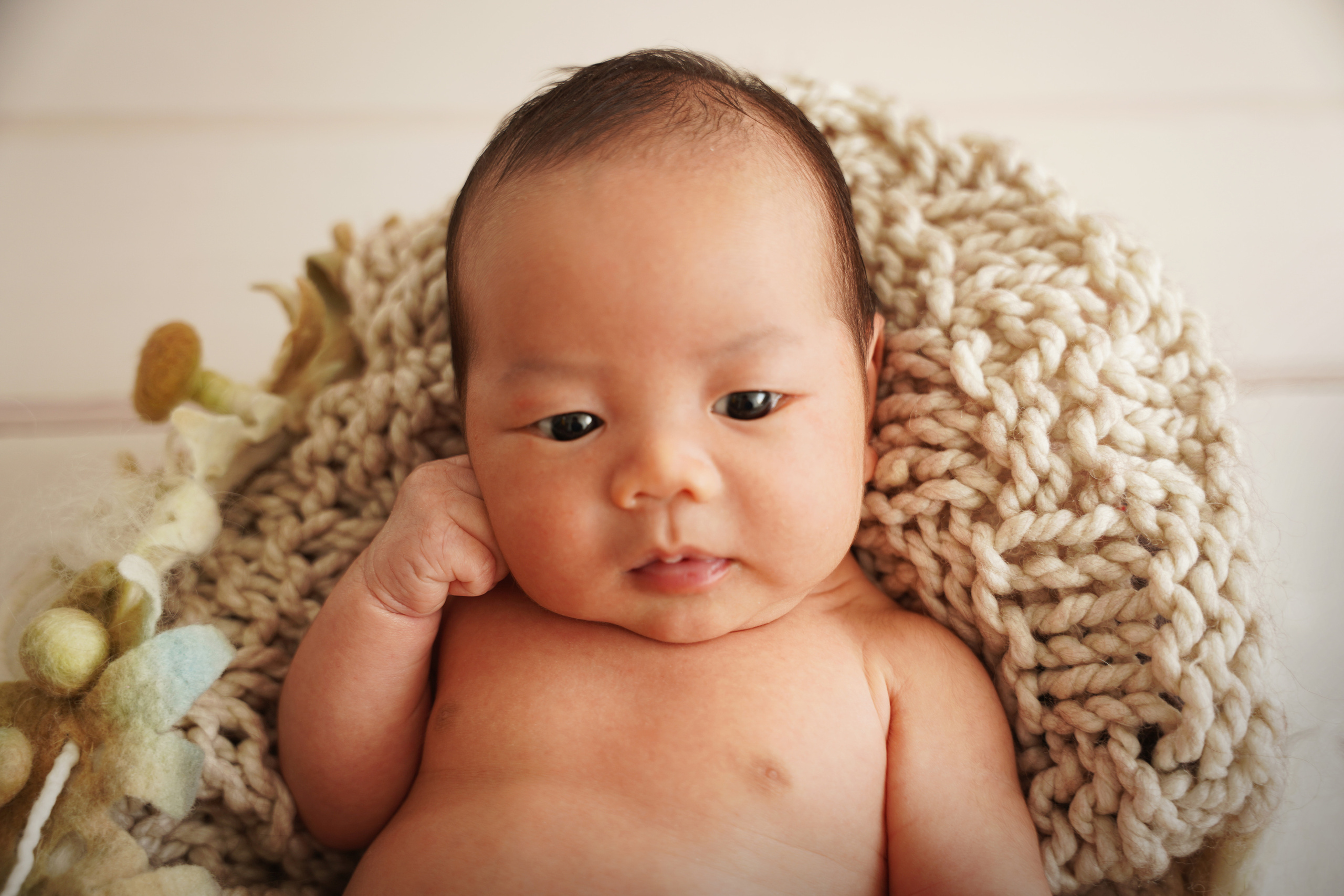 zwei wochen altes Baby stützte sich mit der Hand auf Gesicht