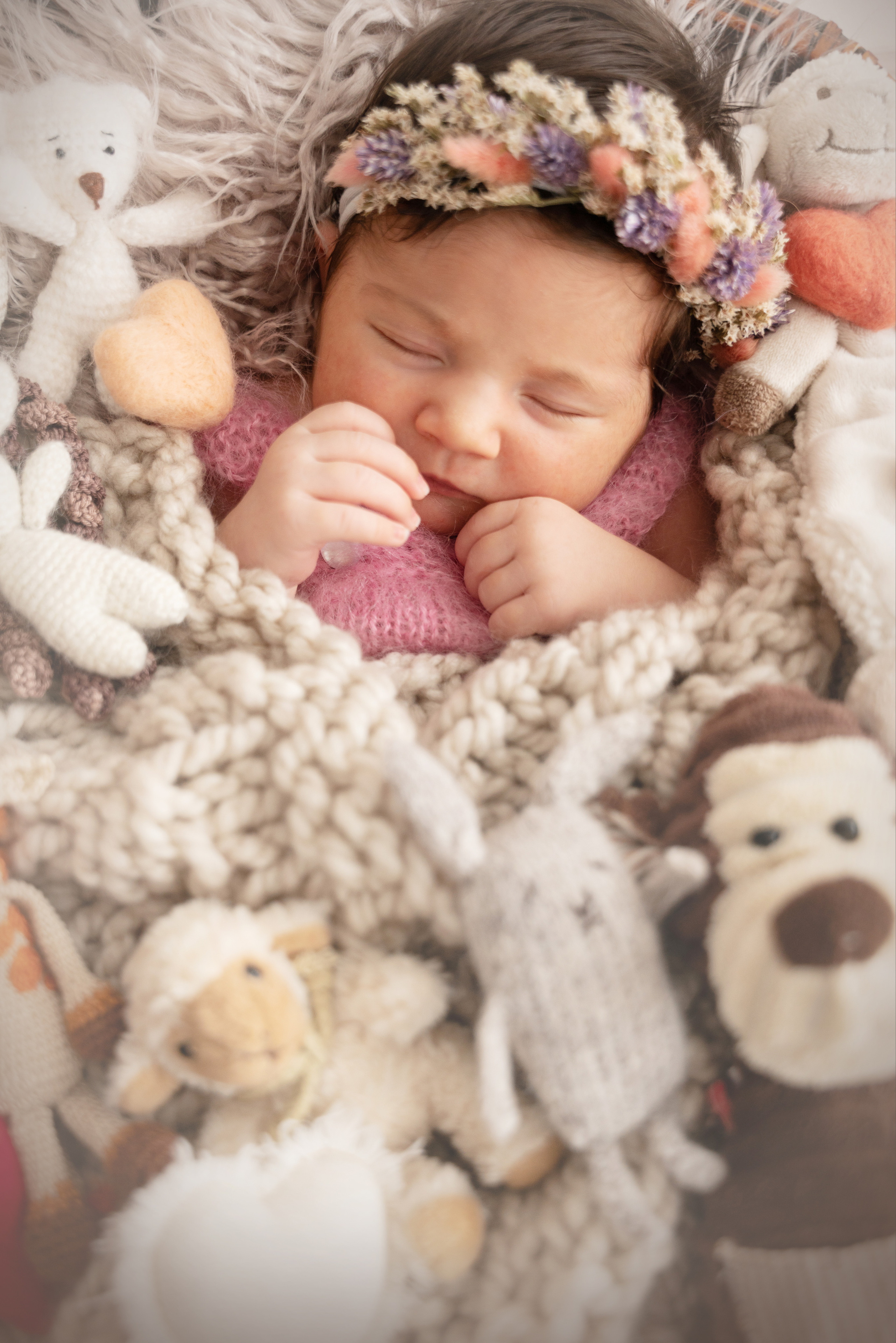 neugeborenes mit einem Kranz auf dem Kopf schläft in ihren Spielsachen
