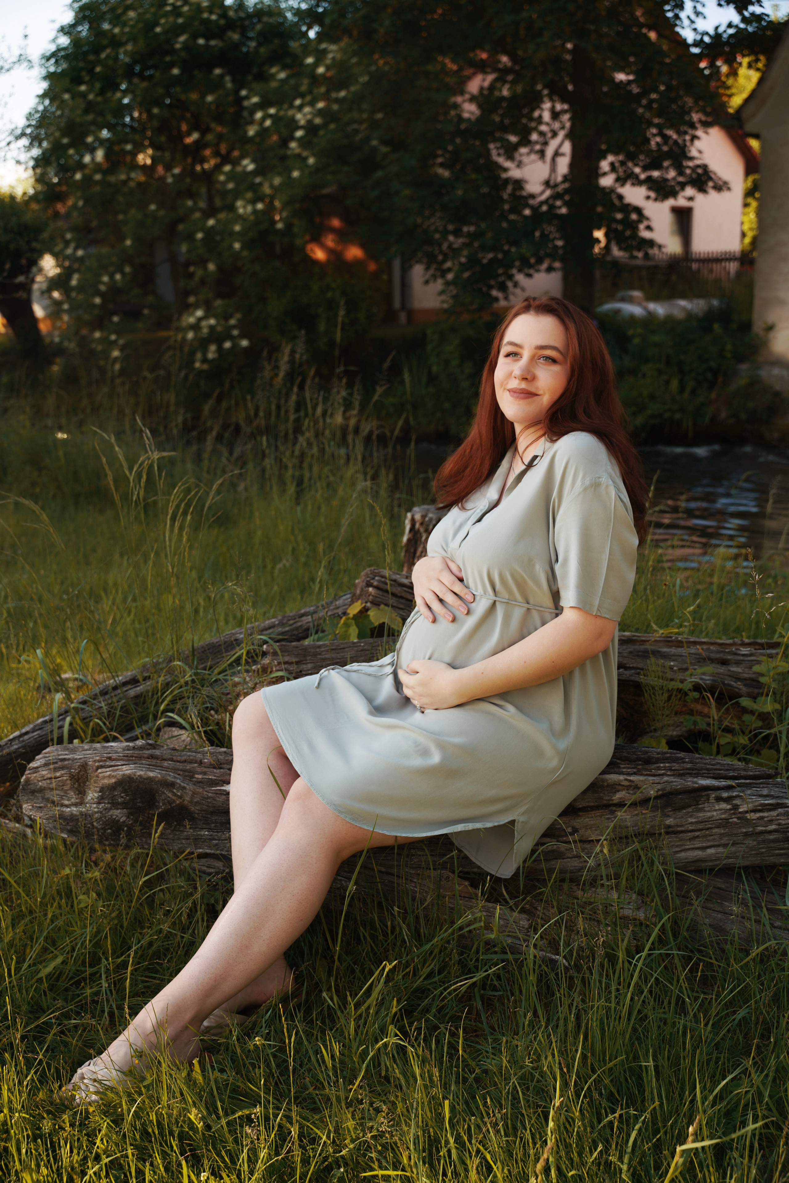 auf dem Foto ist eine schwangere Frau von Grün umgeben