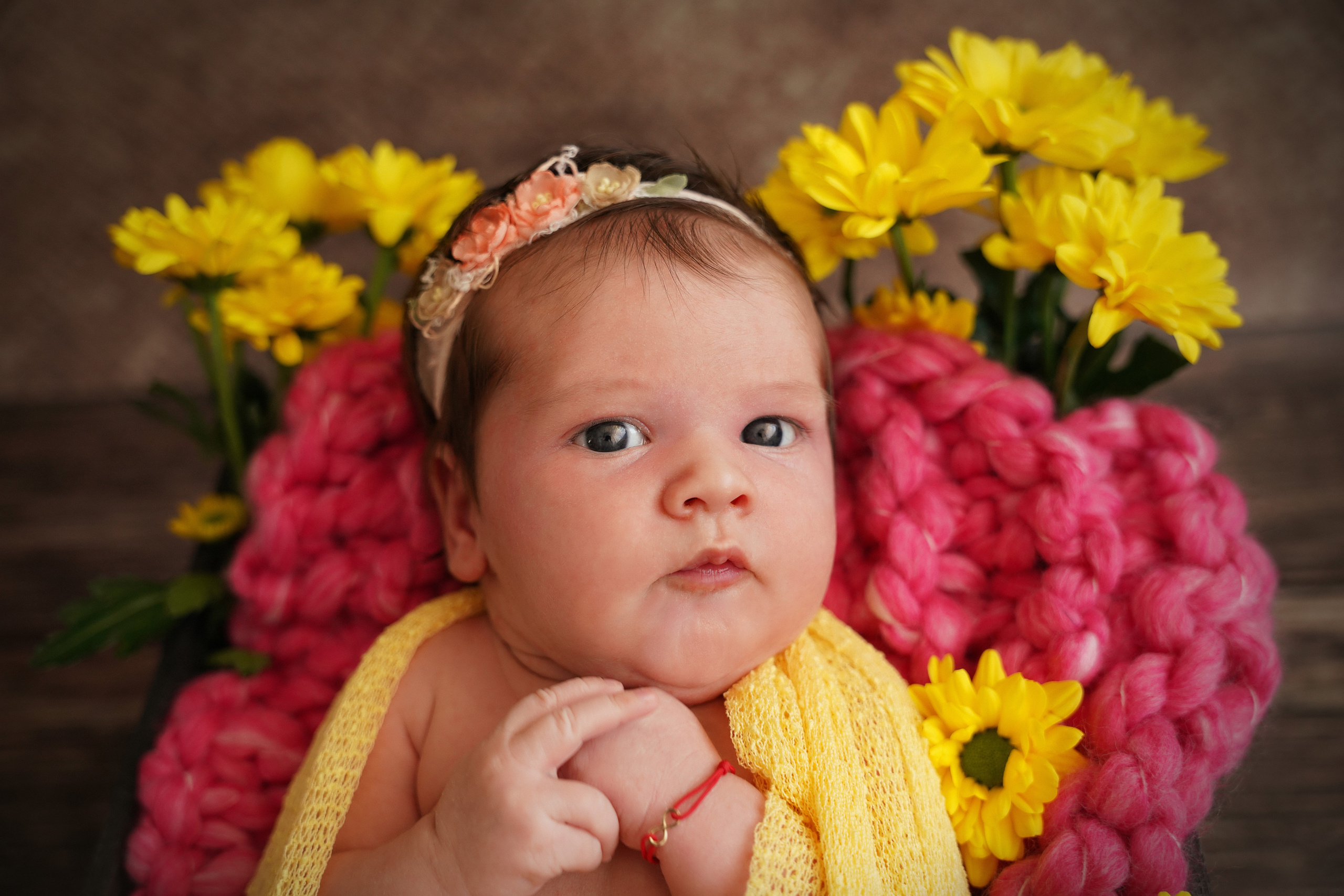 Neugeborenes schaut mit erstaunten Augen in die Kamera