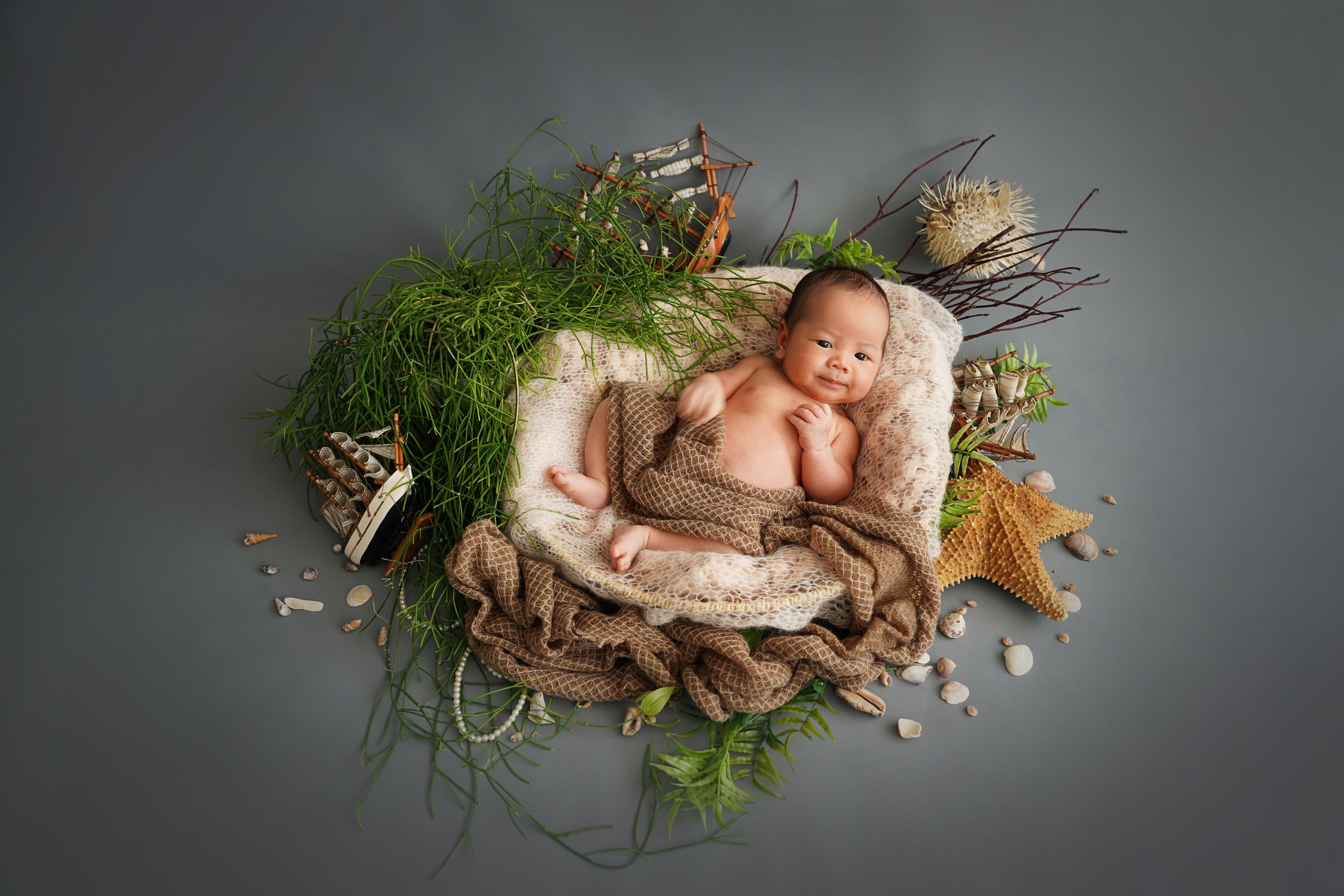 ein neugeborenes Mädchen im Bild einer Meerjungfrau