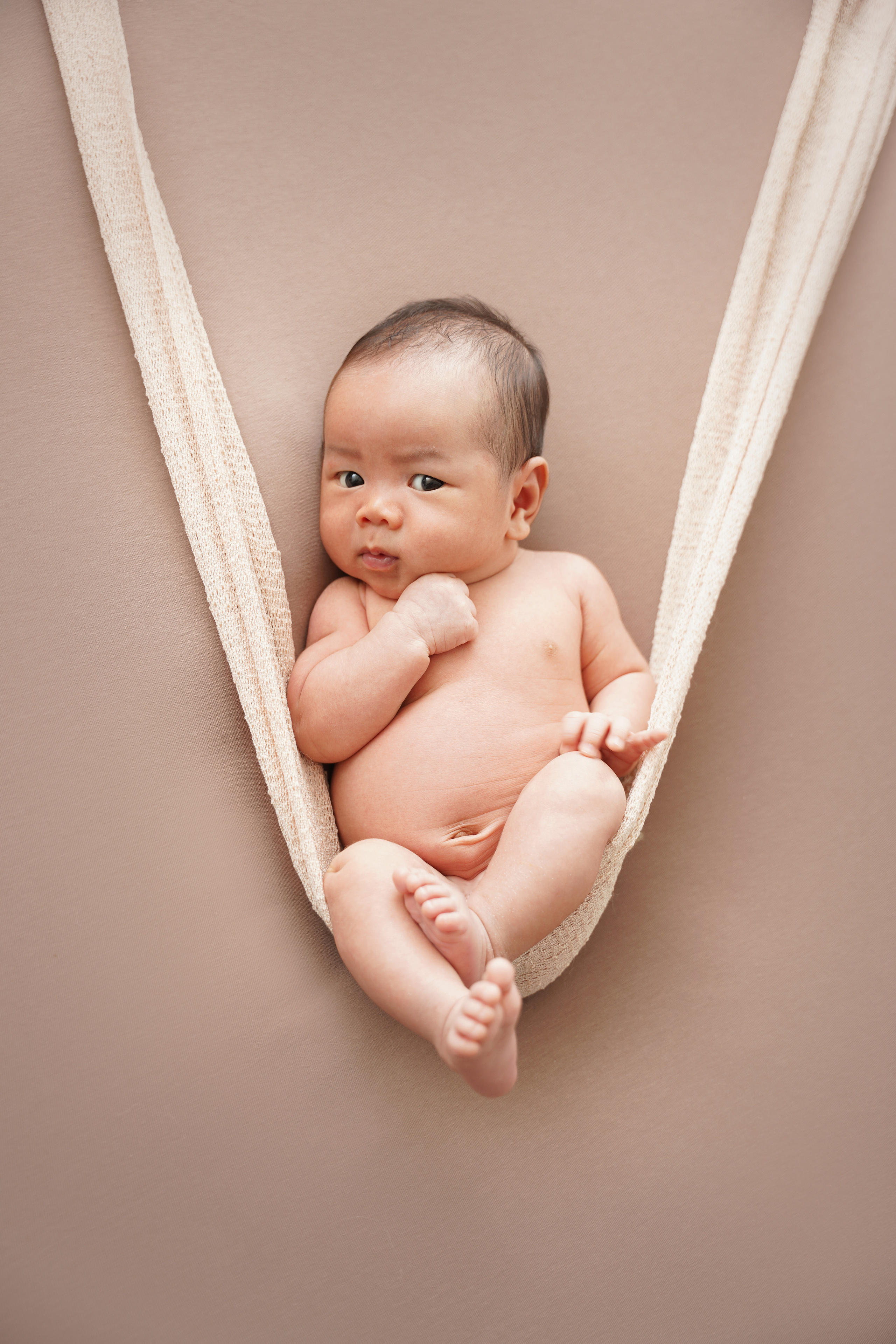 Bild mit einem neugeborenen Jungen auf einer Windelschaukel
