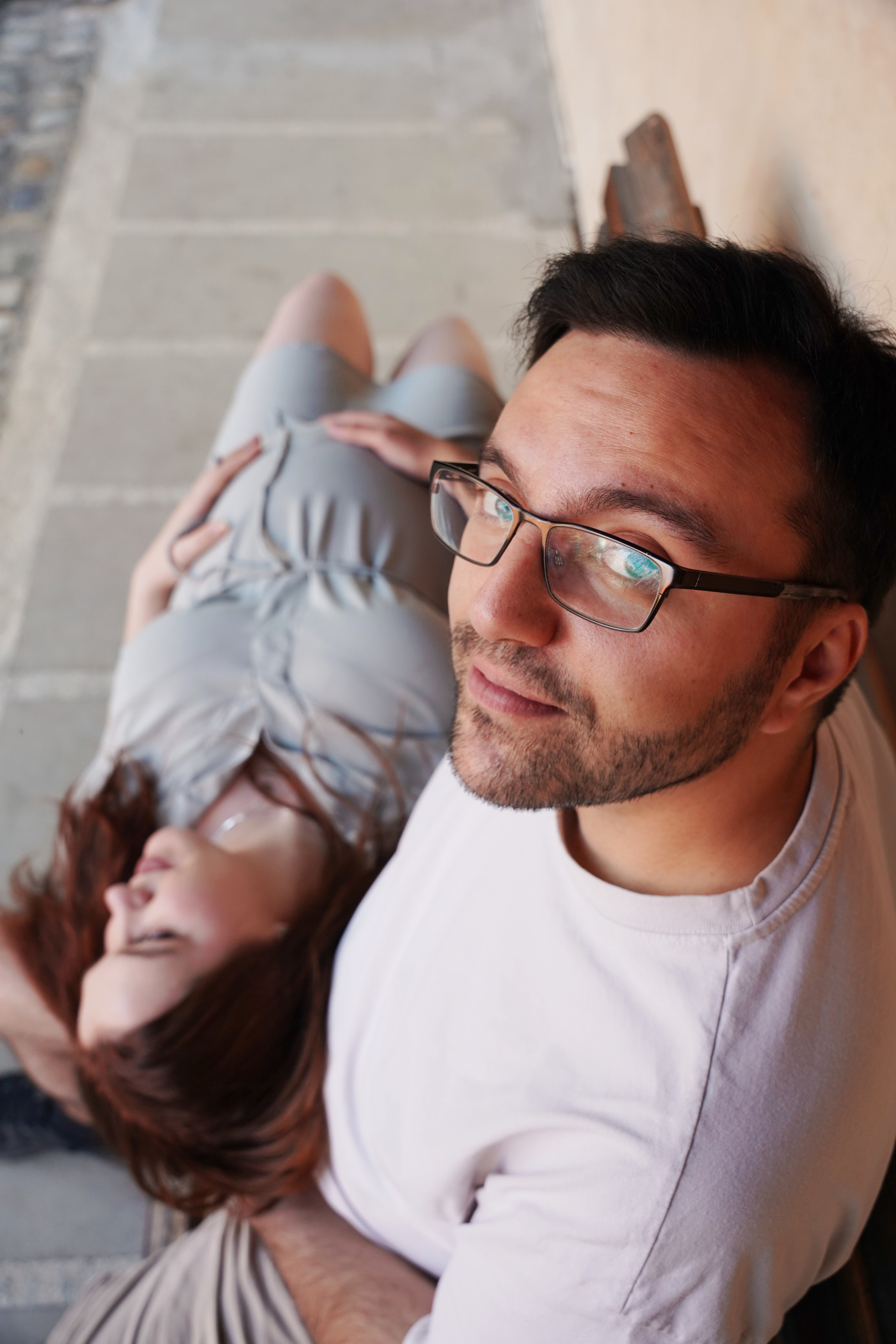 schwangere Frau liegt auf dem Schoß ihres Mannes