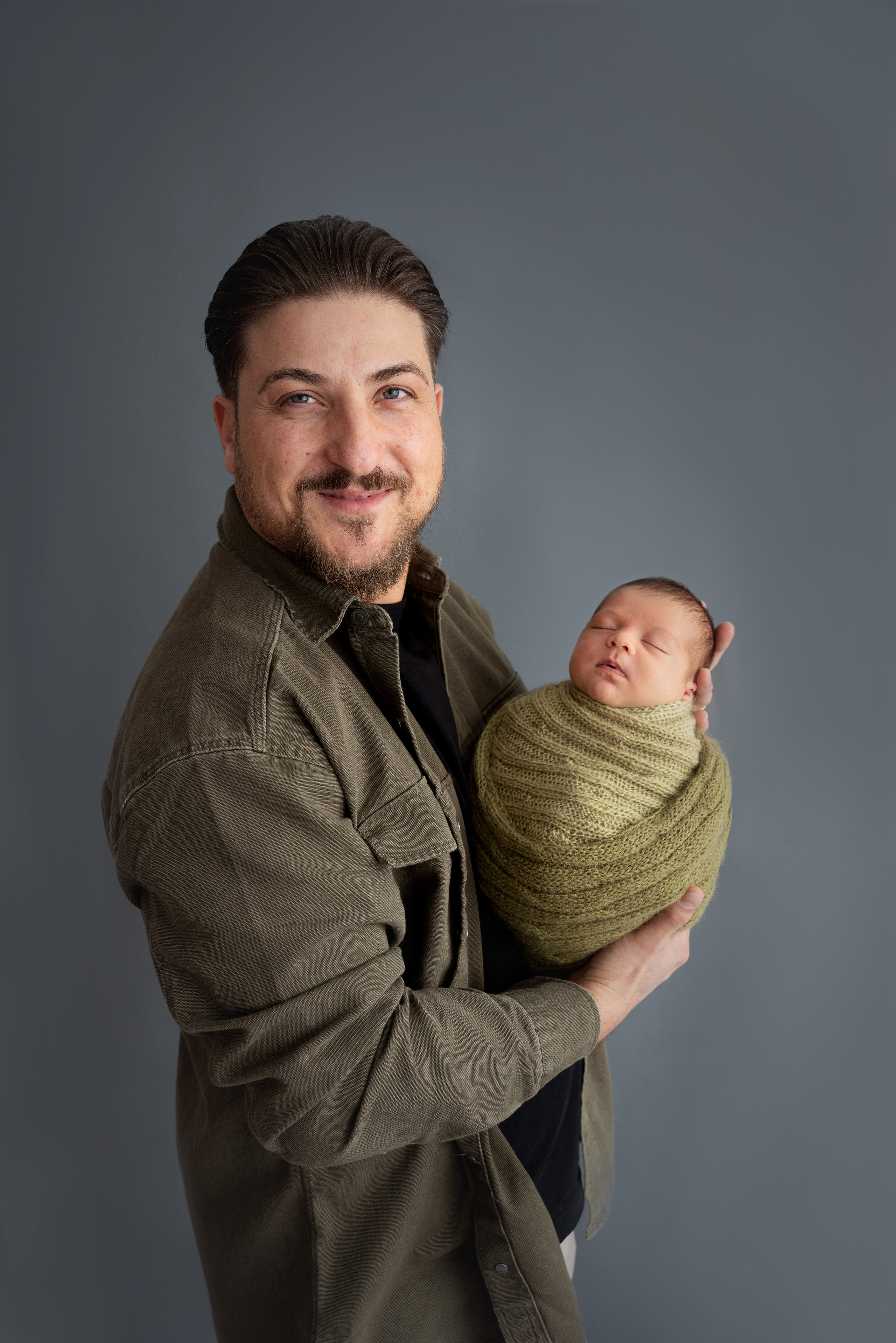 Papa und Baby in seinen Armen lachen glücklich