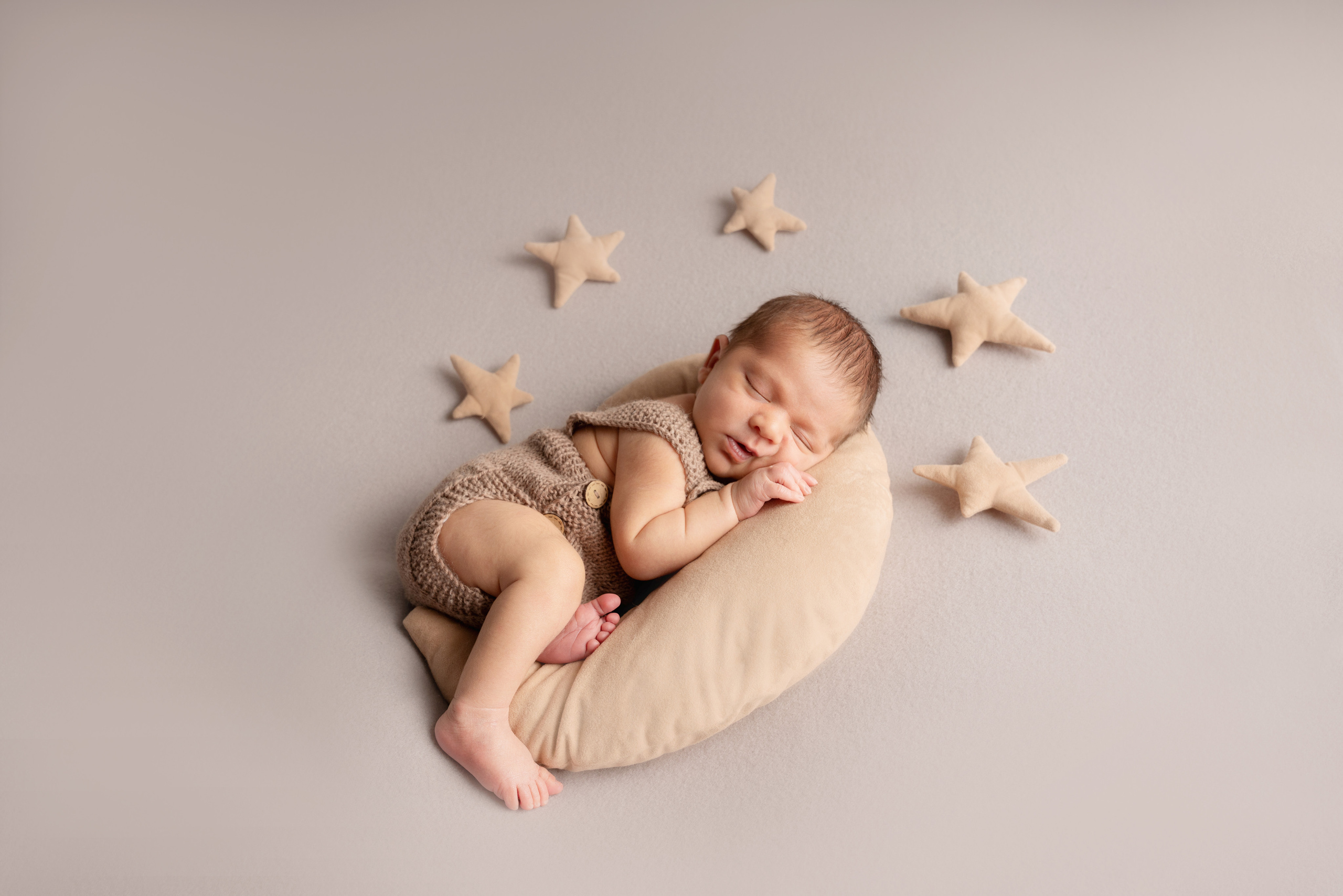 Newbornfoto eines Babys auf dem Mond mit Sternen