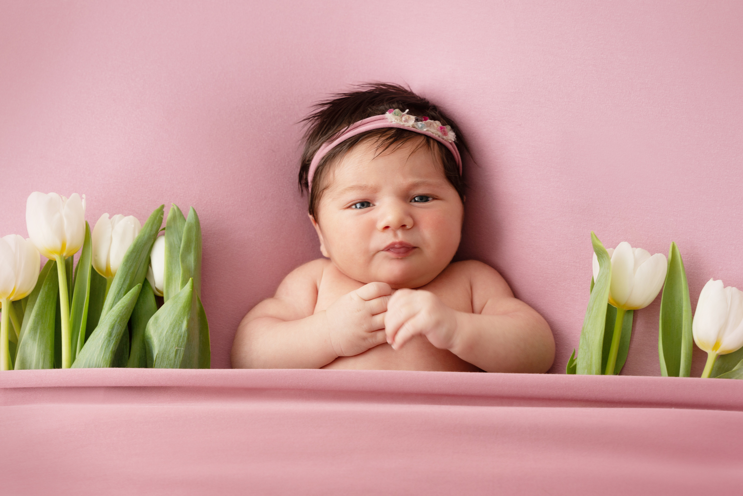 baby liegt unter einer rosa decke mit rosa Tulpen