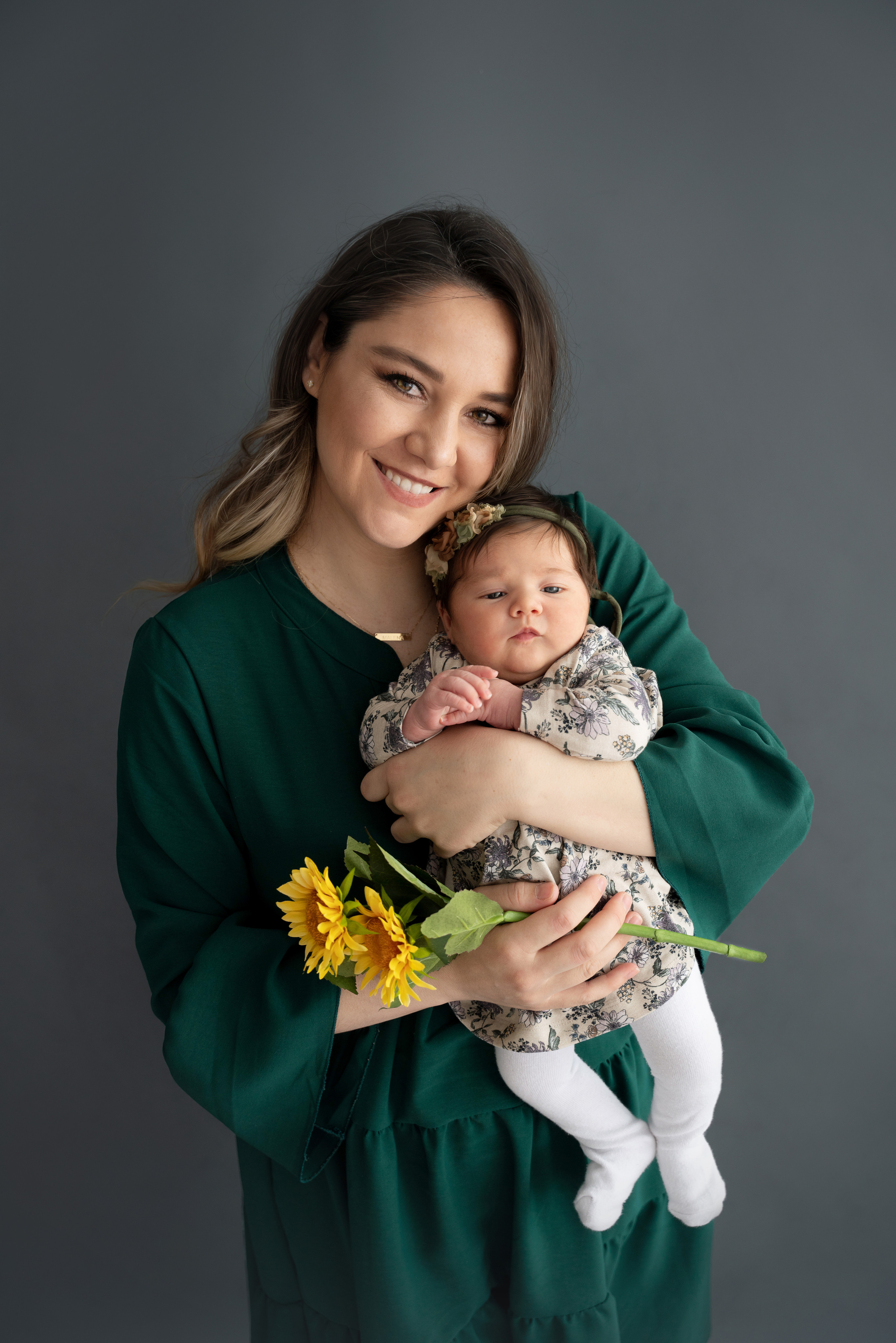 mutter mit sonnenblume in händen umarmt tochter