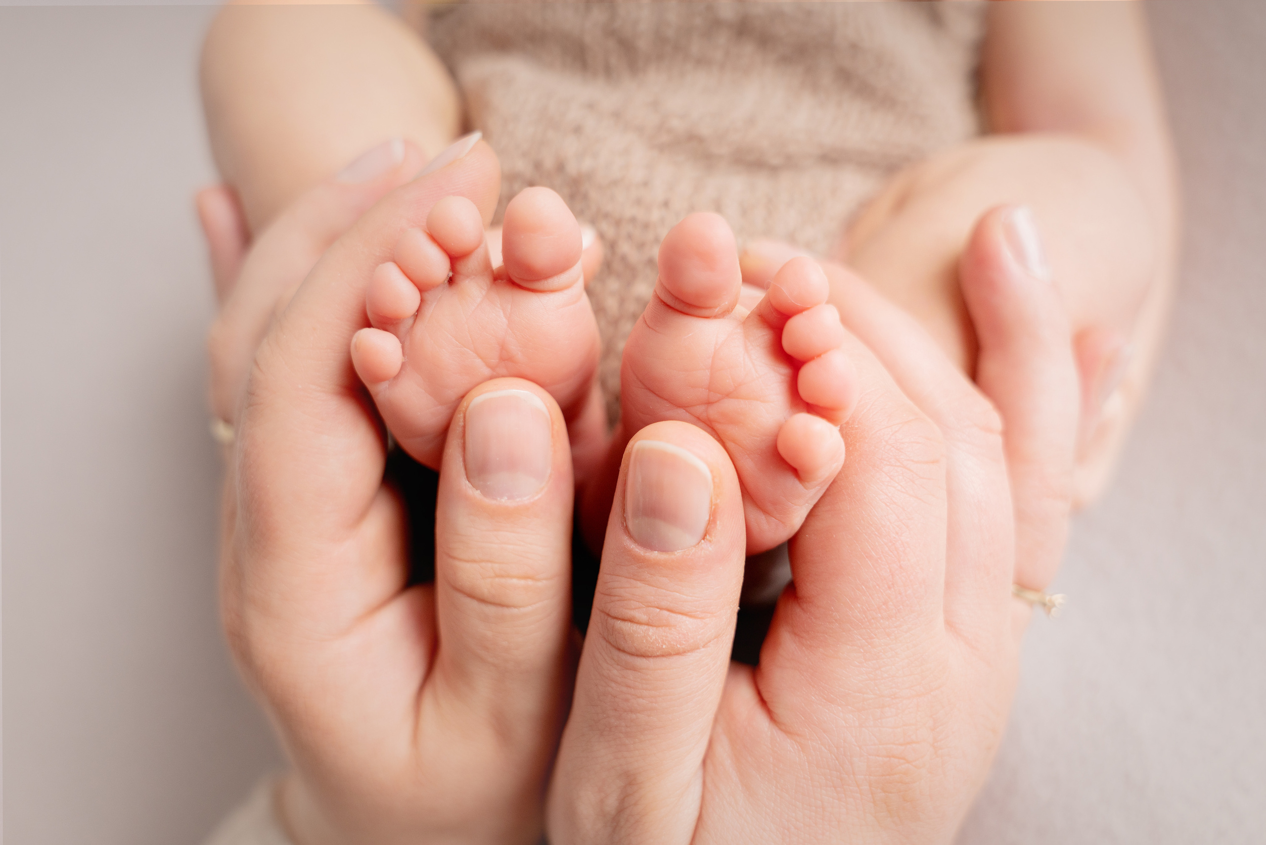 die Füße des Neugeborenen in Papas Händen