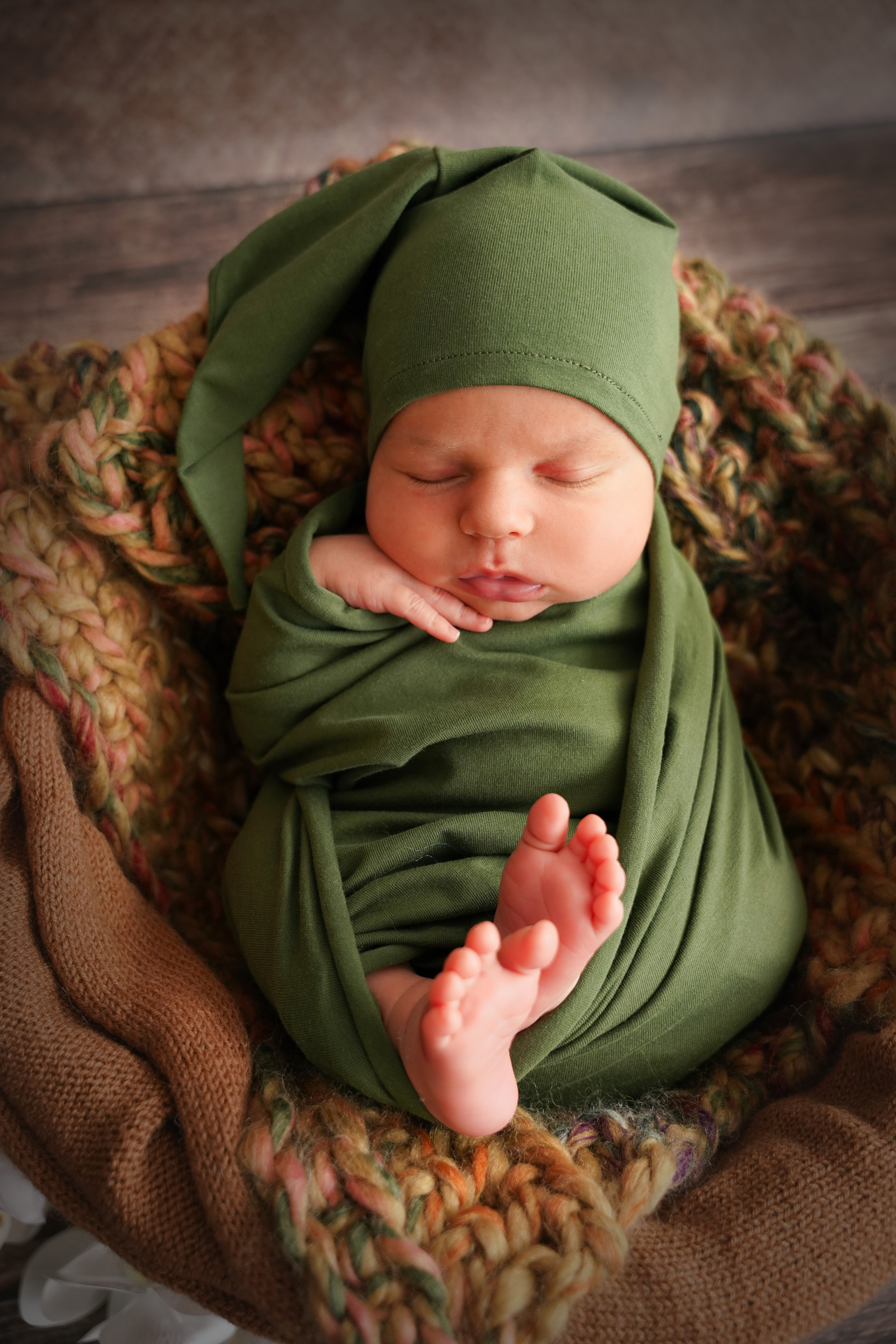 Neugeborenes im Bild eines Zwergs in einer grünen Windel mit einer grünen Kappe