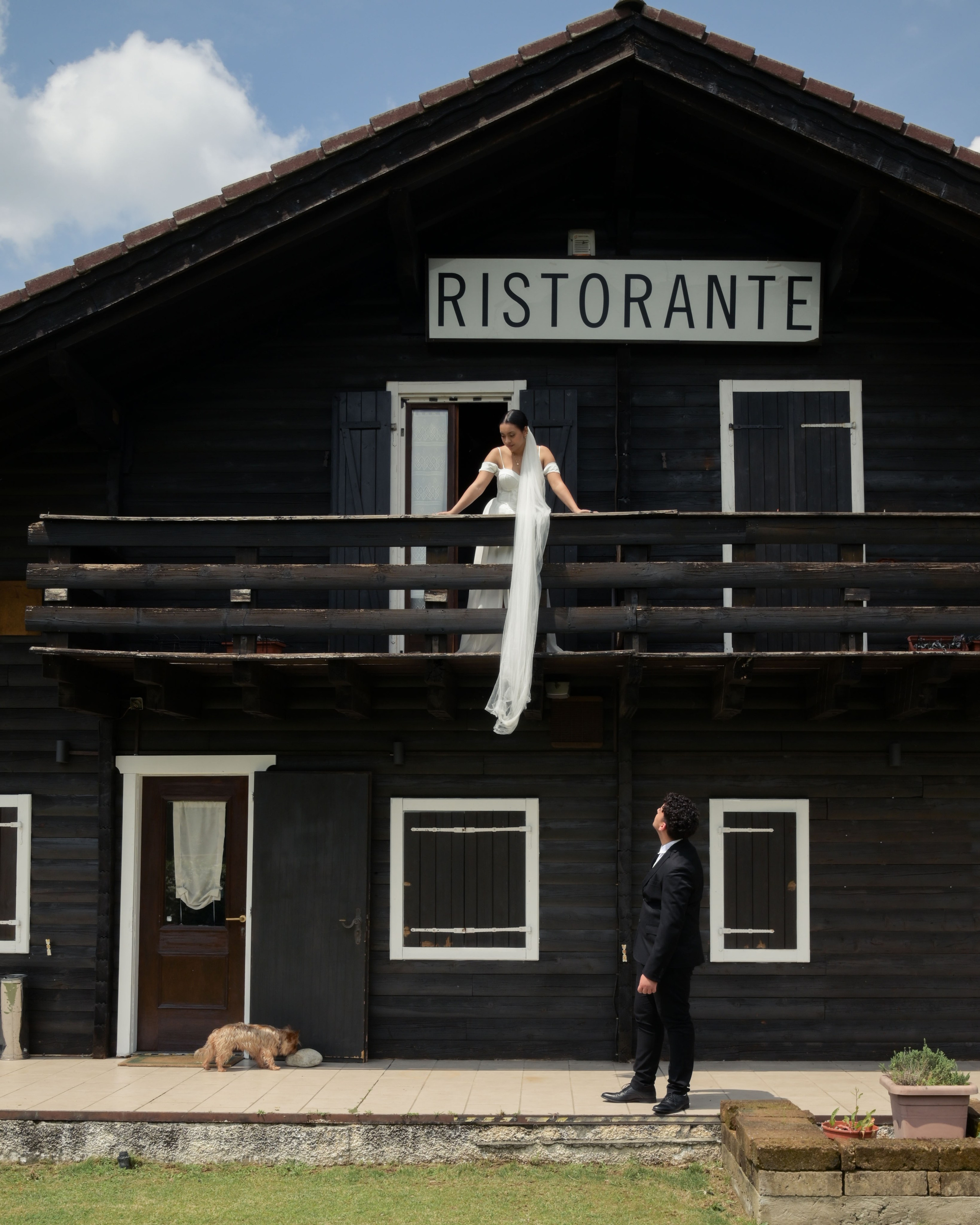 La location tipica della montagna scelta per il ricevimento sul balcone la sposa con il velo che pende mentre sotto lo sposo che la guarda