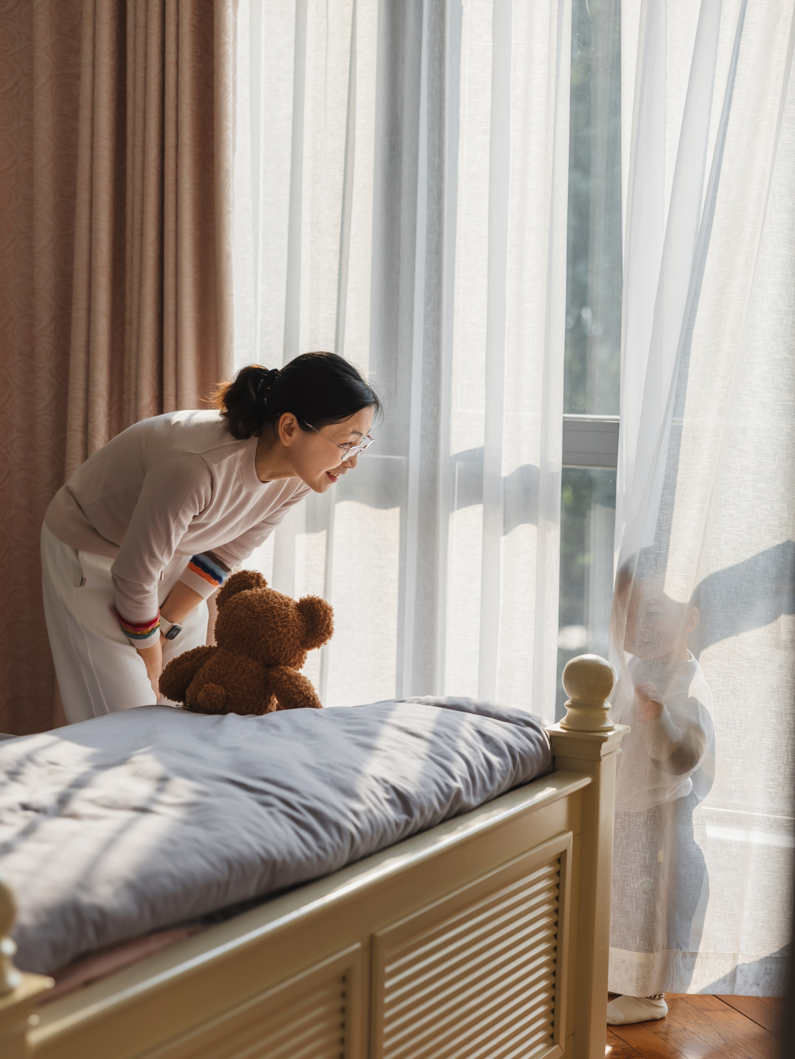 The grandmother and the two-year-old baby are playing hide and seek.