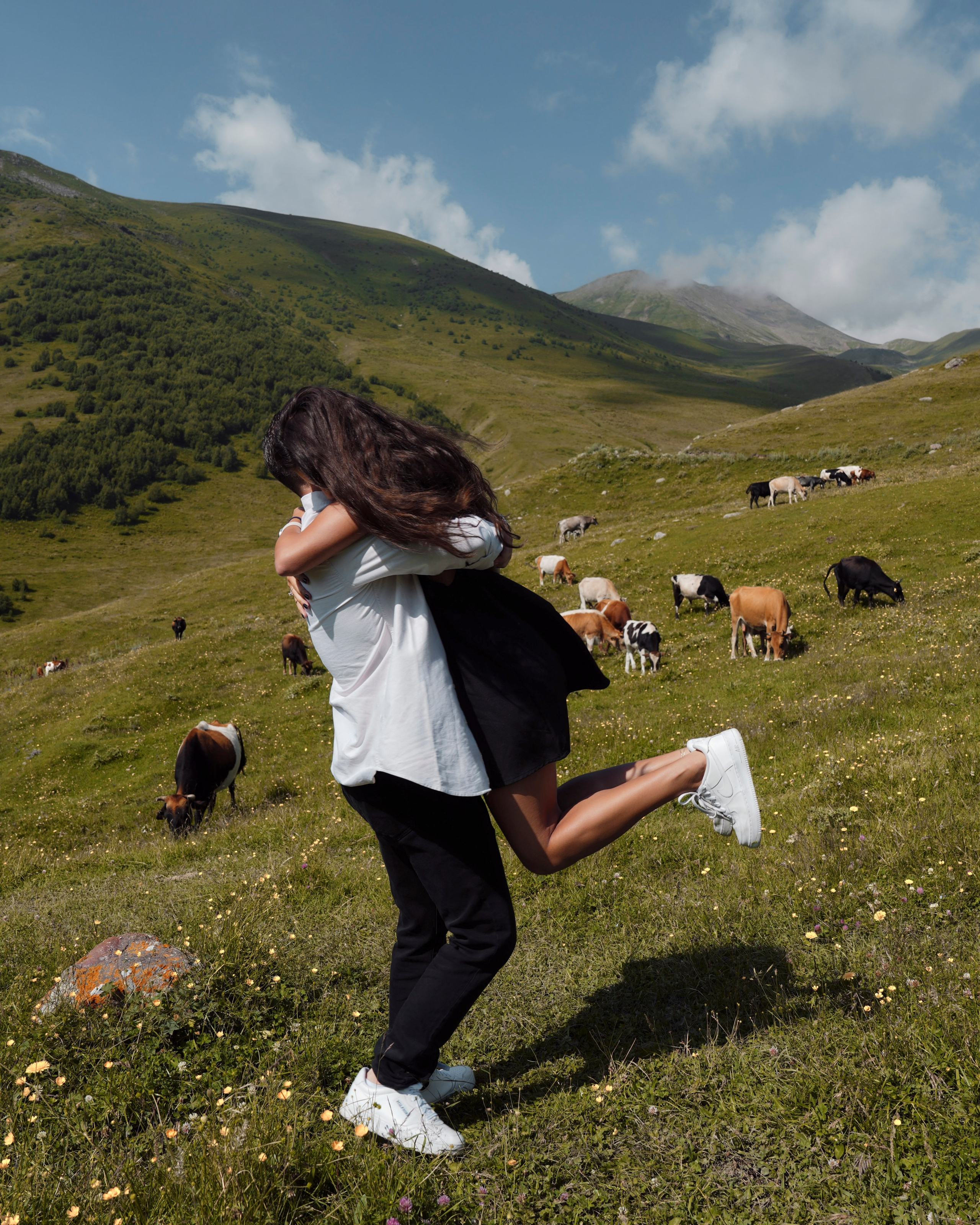 Couple celebrating engagement in Kazbegi with dramatic mountain valley scenery around them