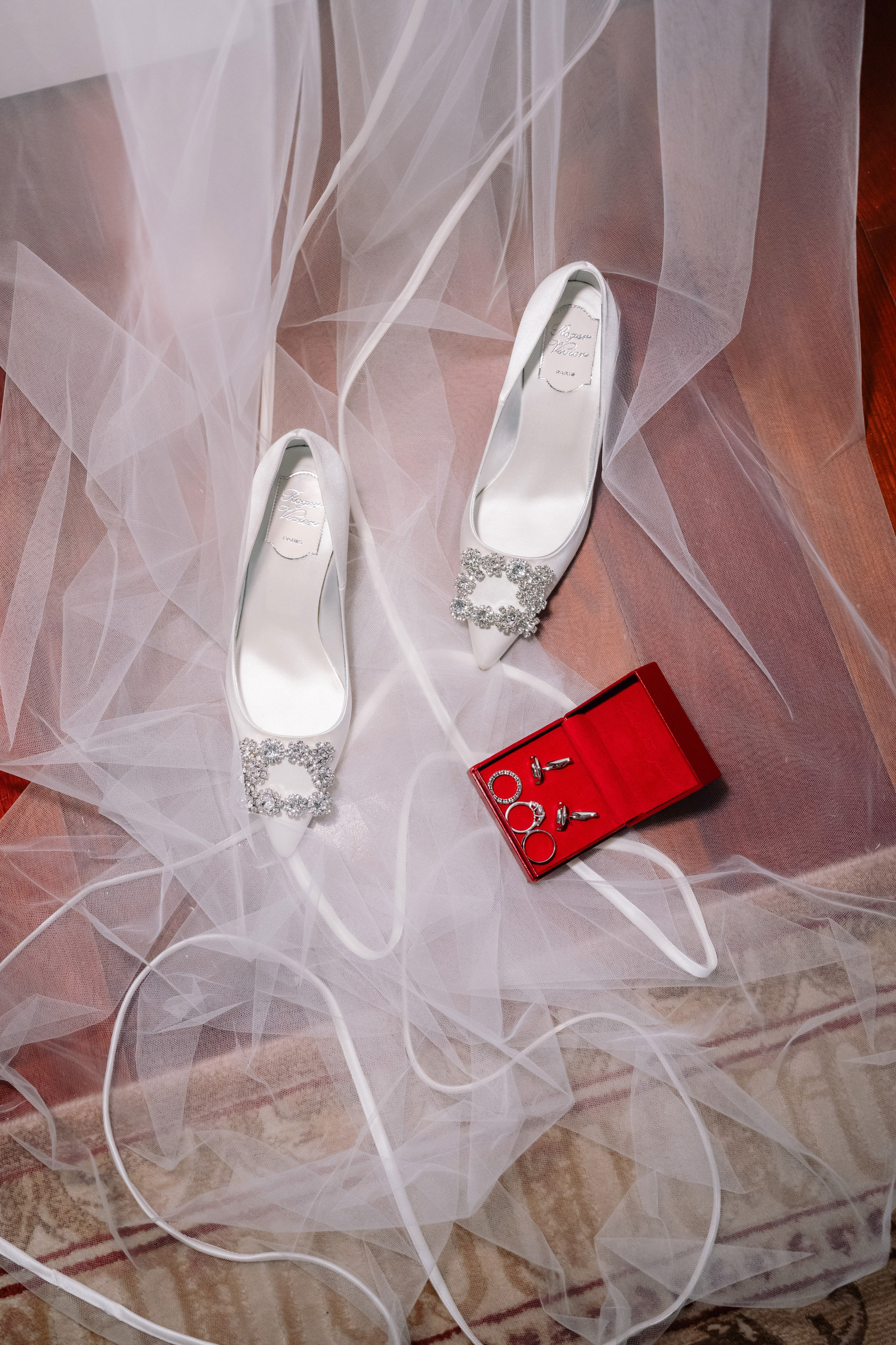 a pair of shoes and a red box on a wooden floor